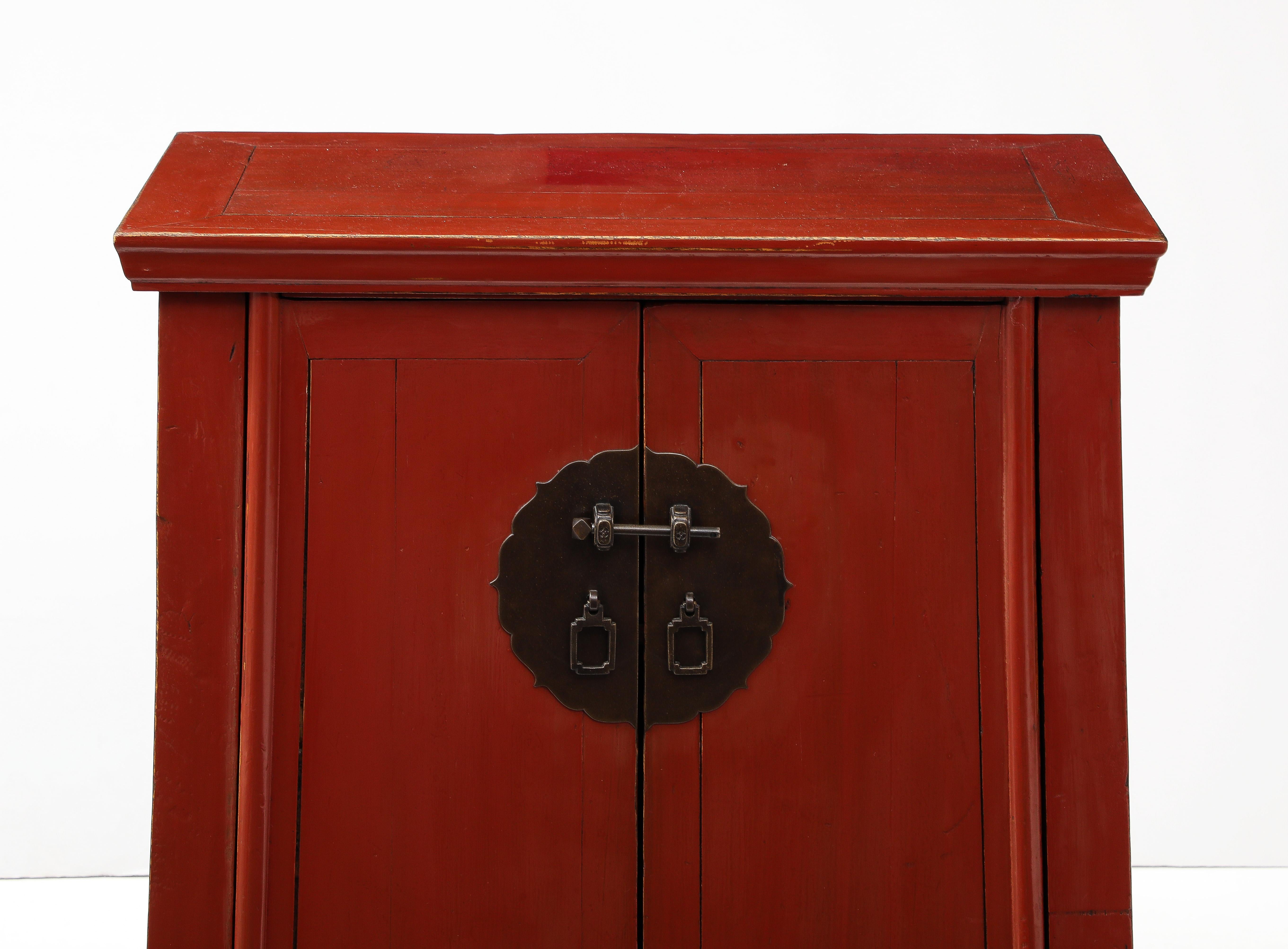 Armadietti del XIX secolo di grande aspetto con una sorprendente finitura laccata rossa.  Decorati con ferramenta originale in bronzo, gli armadi sono sollevati su piedi a blocco.  Le due porte si aprono su un'area di stoccaggio con un ripiano.  Le