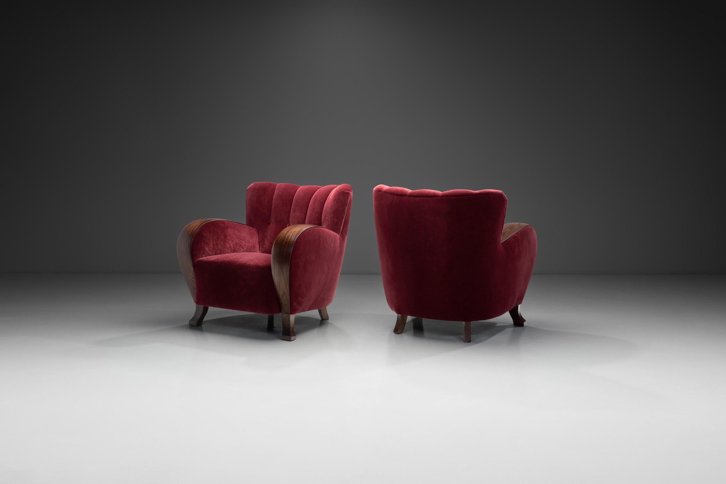 This pair of exquisite armchairs embodies the timeless elegance and craftsmanship of a bygone era. They showcase the perfect balance between subtle intrigue and a traditional look.

One striking aspect of these chairs is their scalloped back, which