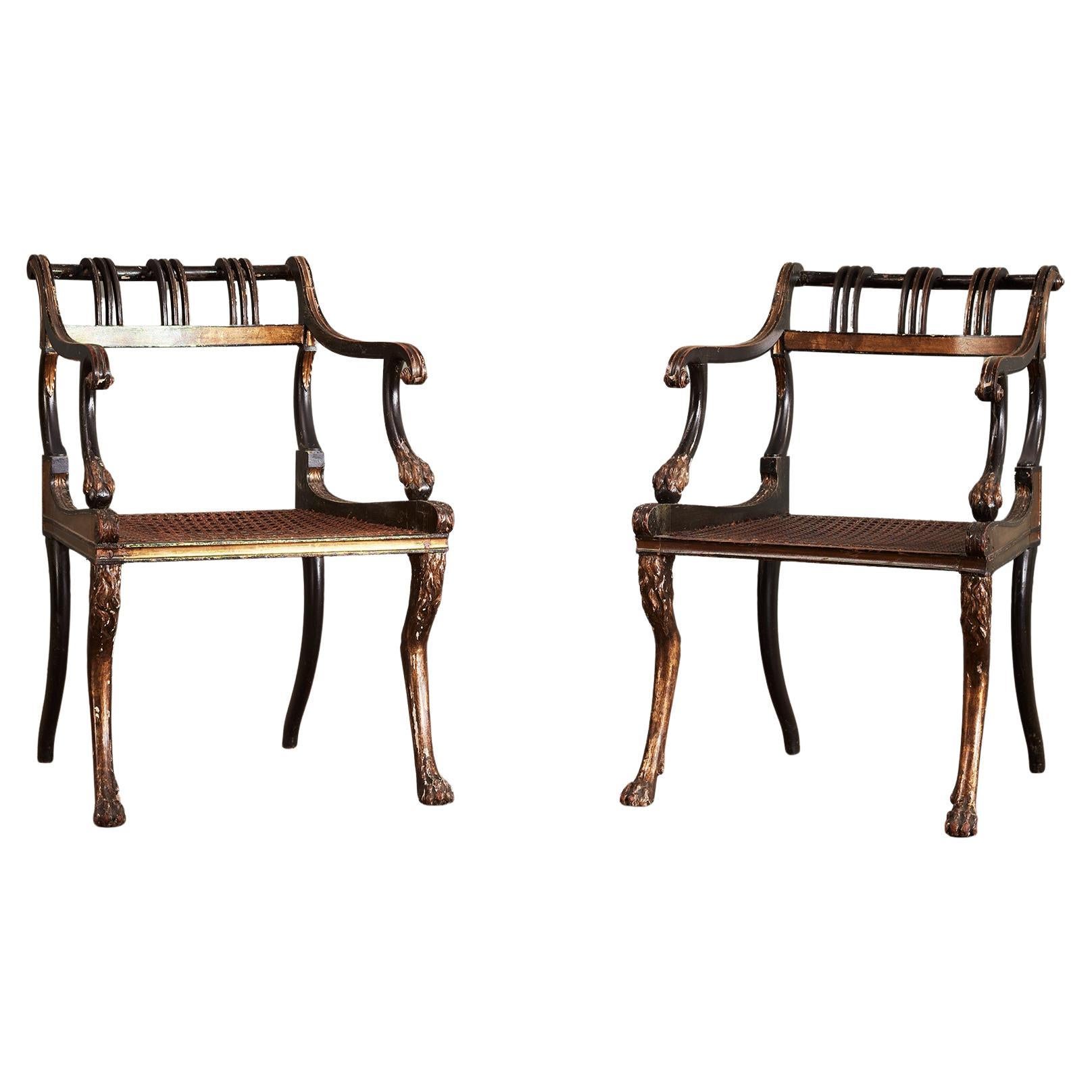 A Pair of Regency Ebonised and Parcel Gilt Armchairs