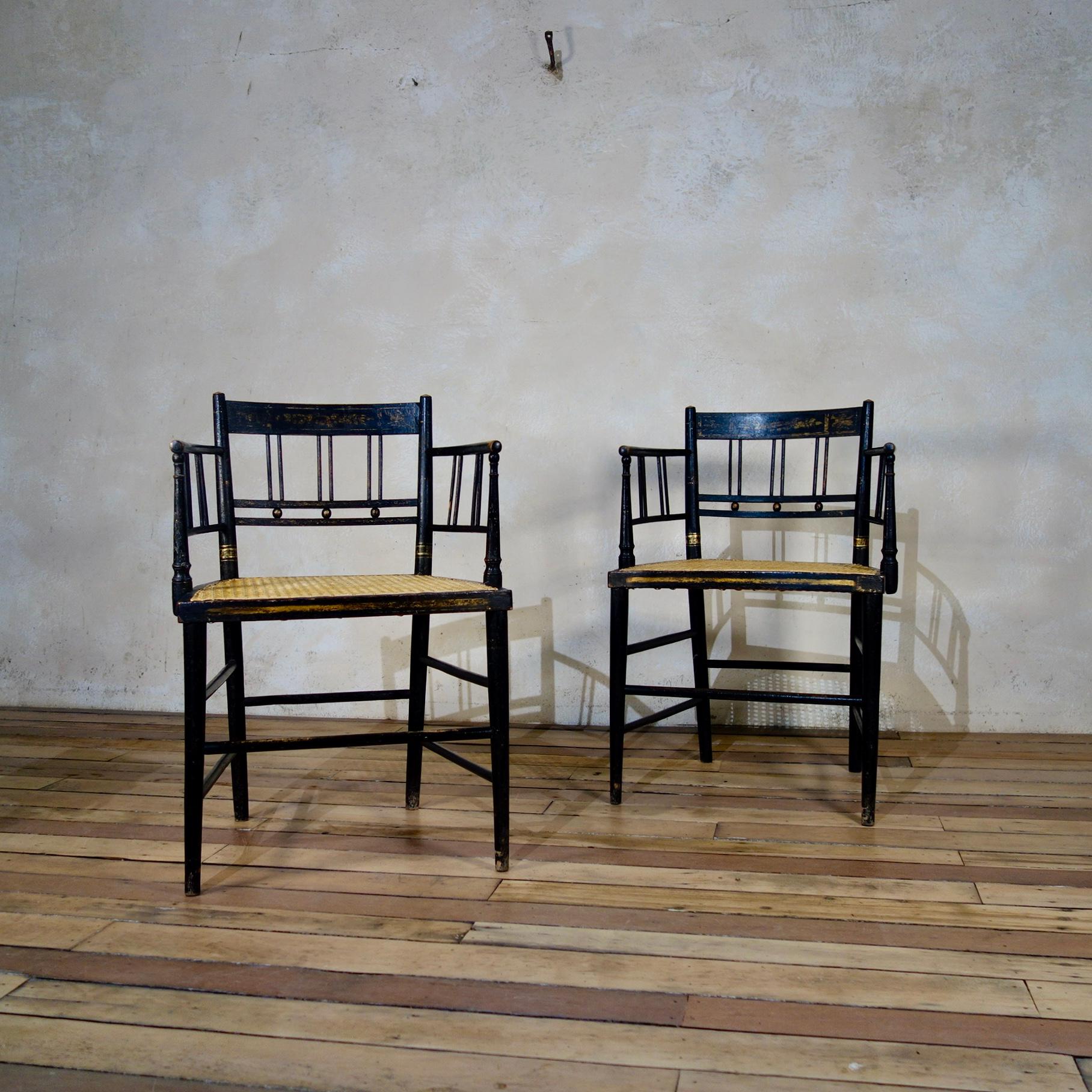 An elegant pair of early 19th century, Regency ebonized armchairs, displaying gilded decorations throughout. The pair have recently been re-caned.

Height -80cm 
Width - 55cm 
Depth - 50cm 
Seat Height - 45cm 
Arm height - 69cm 
