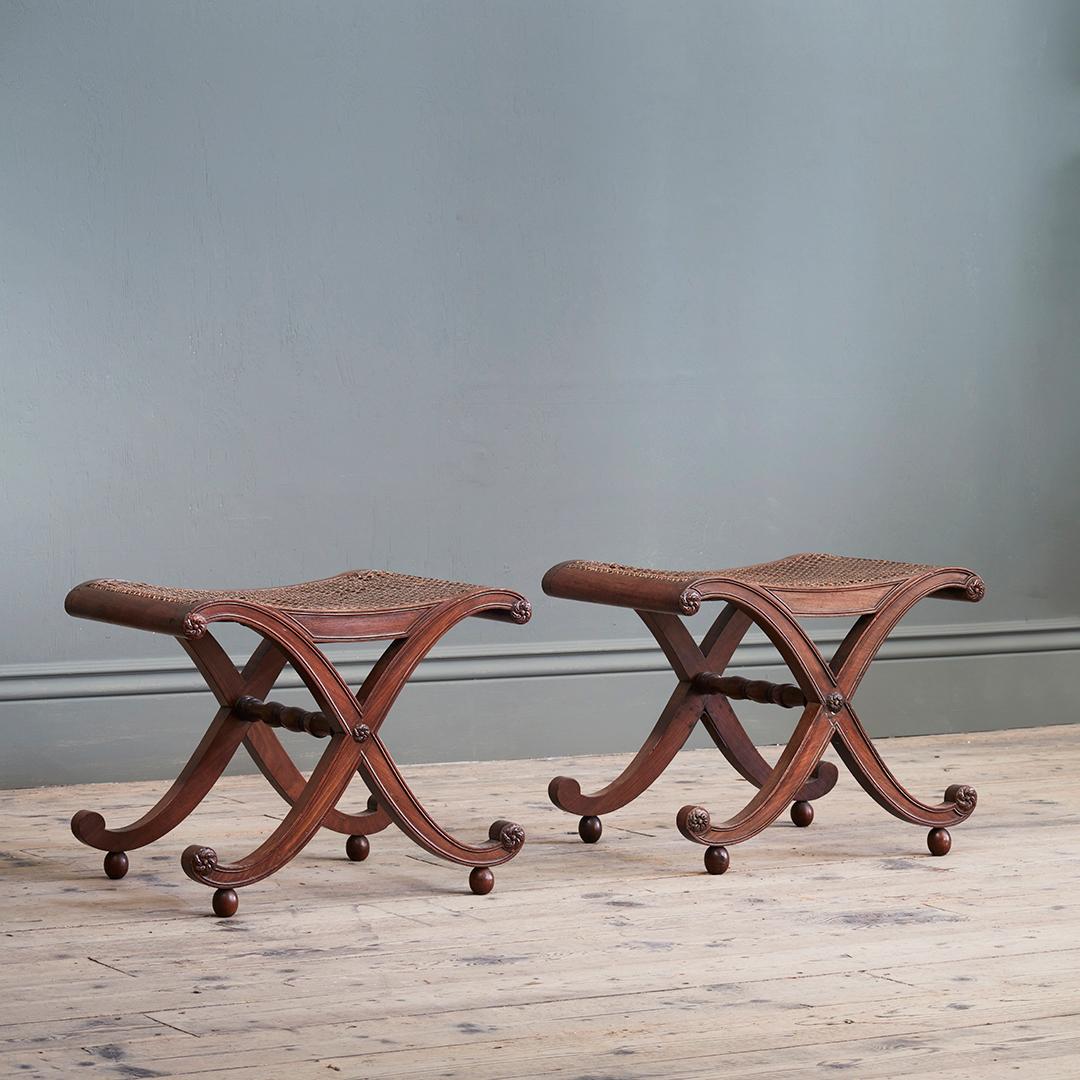 The sabre moulded legs joined by a rail with paterae ends, resting on bun feet with bergère caned saddle seats, supported by mahogany panels, on round feet. A Gillows design, published in 1827.