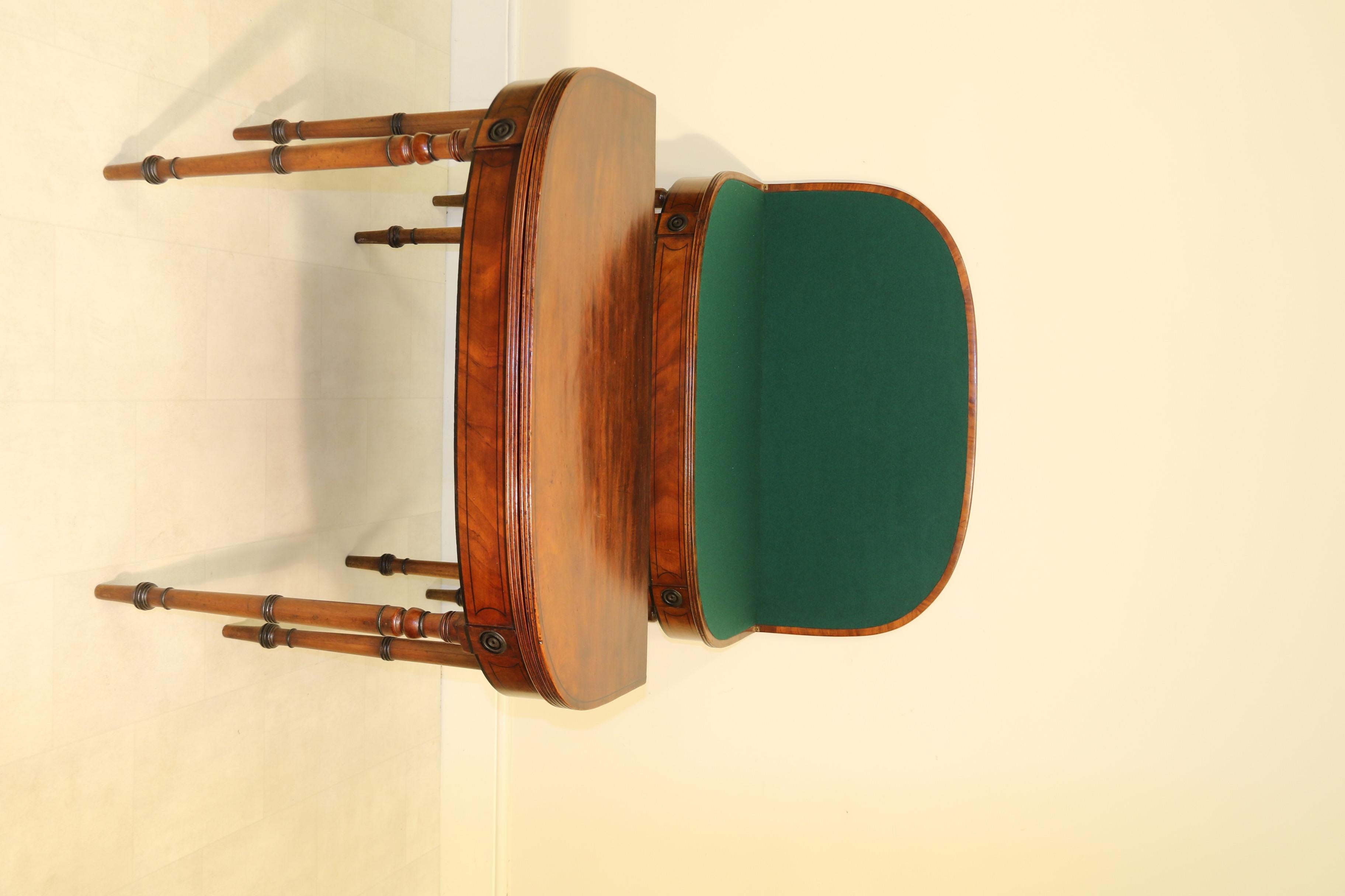 This fine pair of elegant and well proportioned figured mahogany card tables Stand on slender ring turned legs with ebonized turned patera at the tops which form part of the shallow frieze which is decorated with an ebony lined boarder.
The