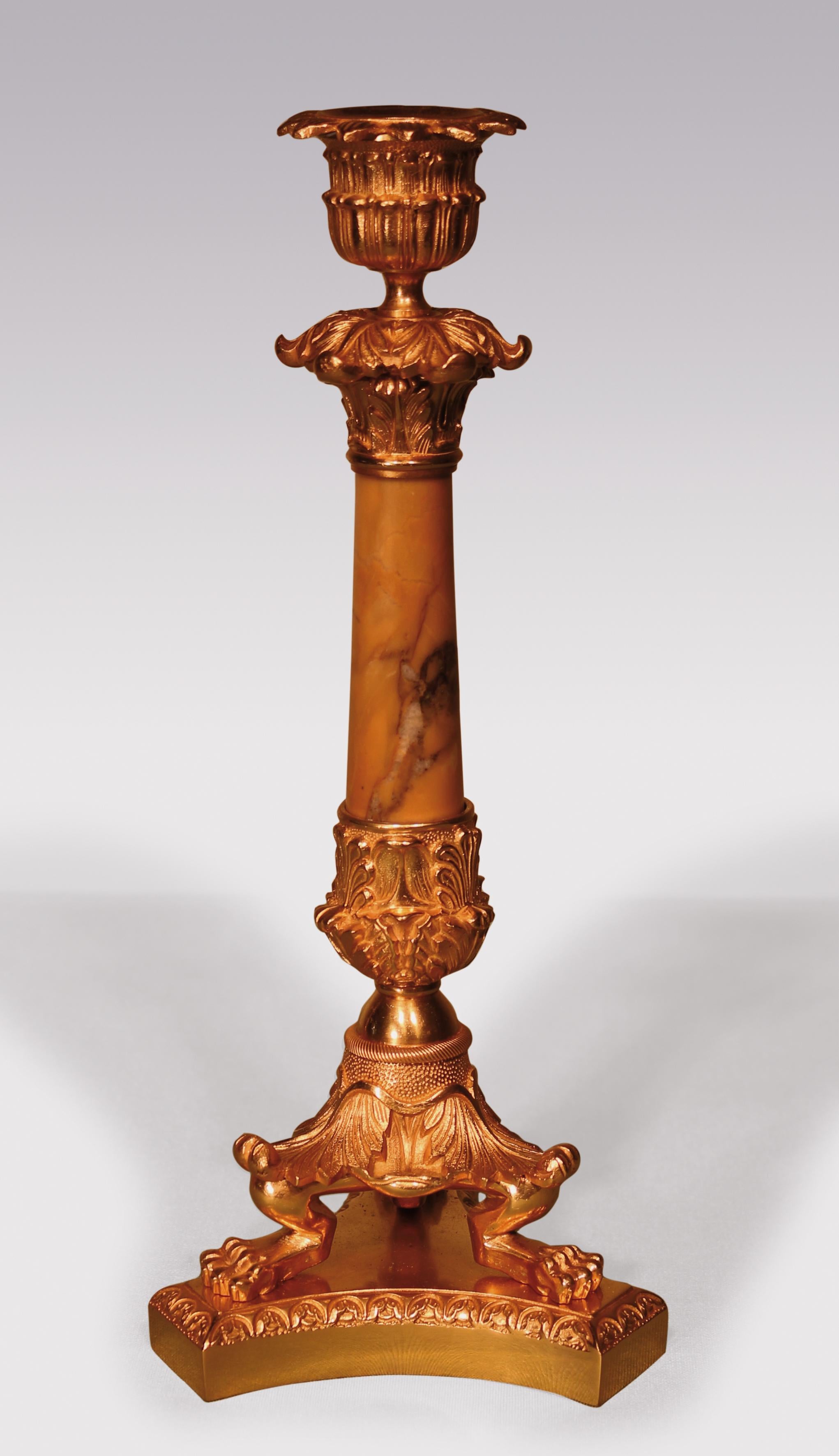 A pair of early 19th Century ormolu Candlesticks, having double leaf decorated sconces above tapering Sienna marble stems raised on acanthus leaf & lion’s paw triform feet ending on concave bases.