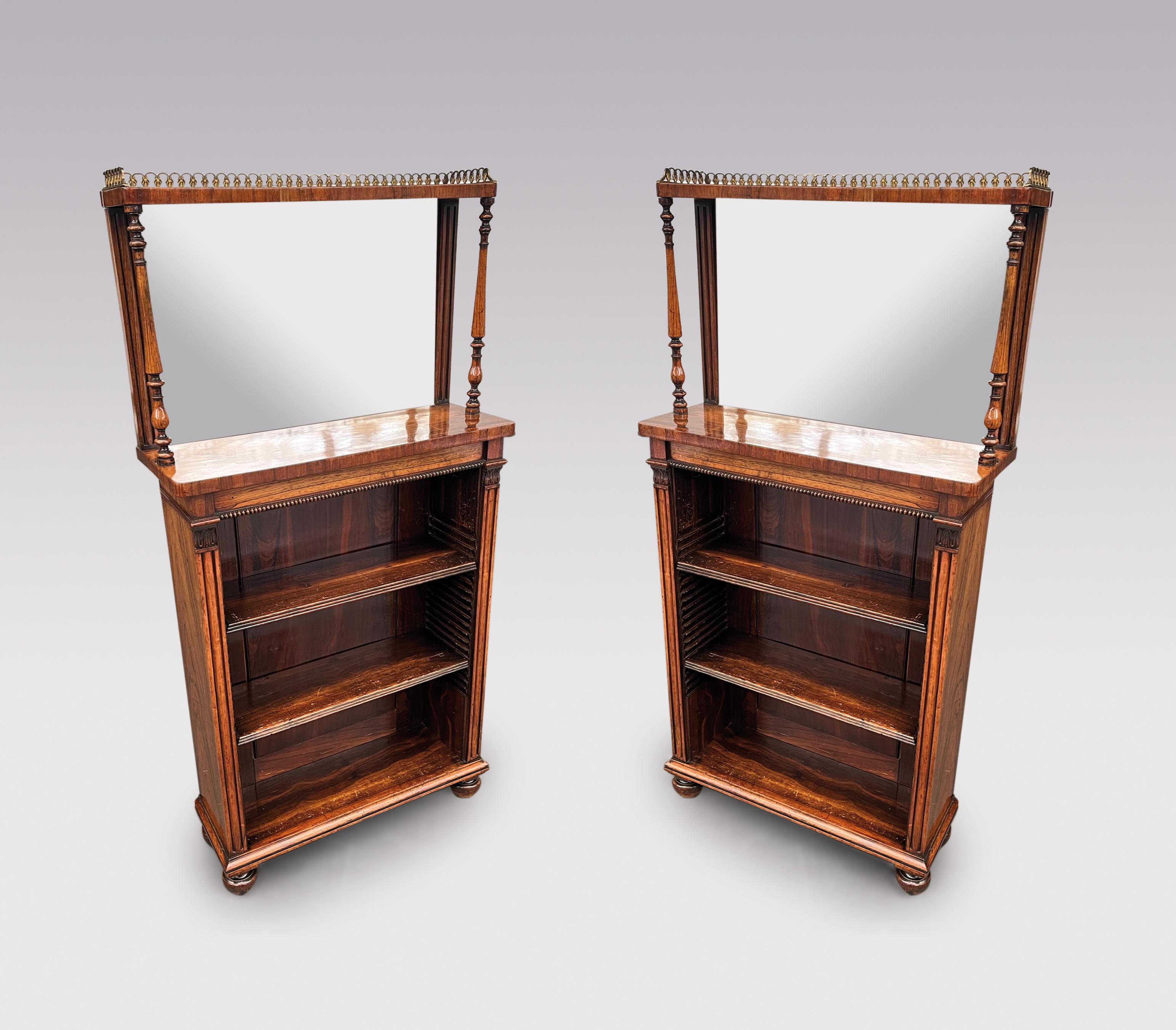 Una coppia di librerie a giorno in palissandro figurato del periodo Regency del XIX secolo di piccole proporzioni, alla maniera di Gillows of Lancaster, con parti superiori a specchio con gallerie in ottone che sovrastano fregi perlinati e ripiani