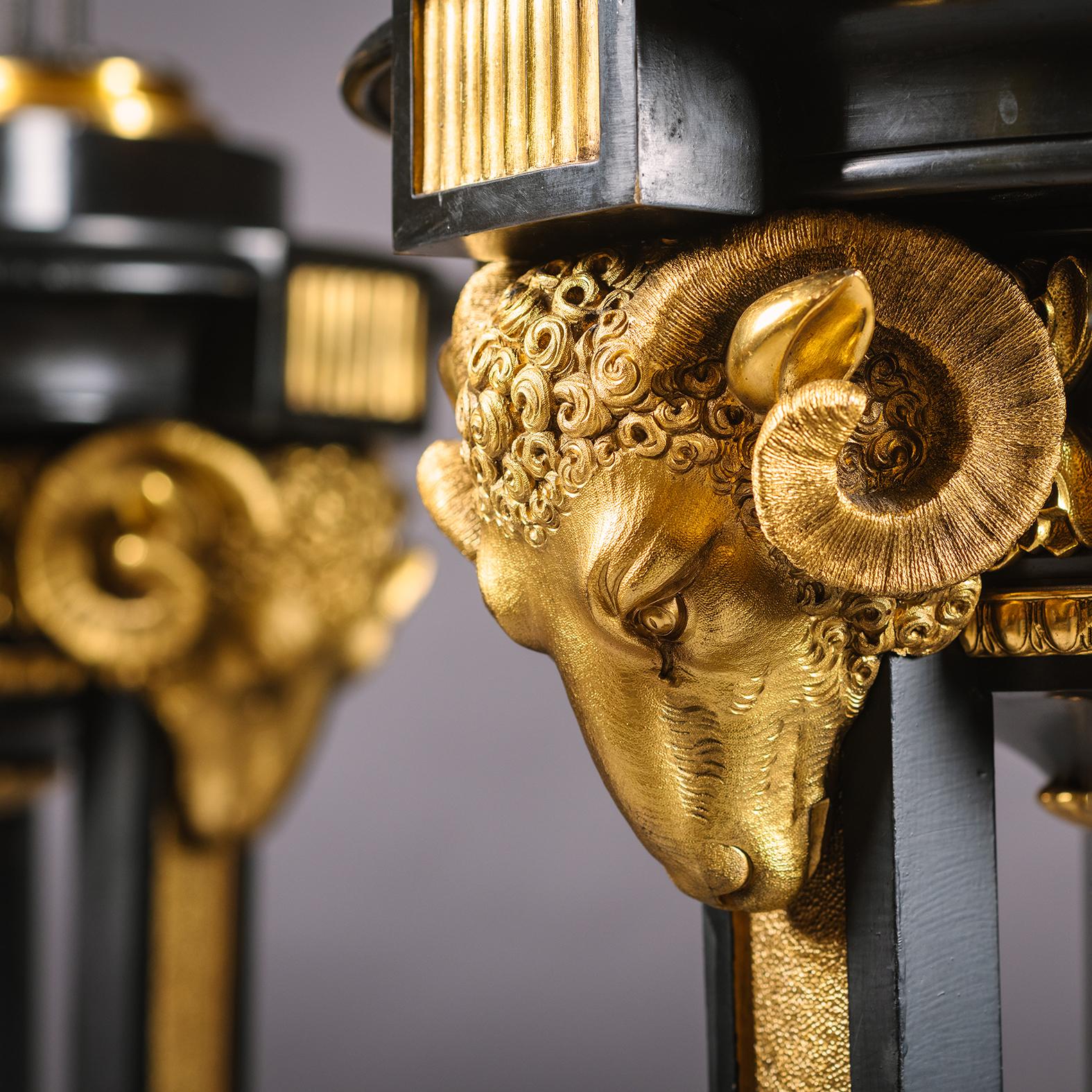 A Pair of Regency Style Gilt and Patinated Bronze Floor Lamps or 'Torchères', After The Models By James Smethurst of New Bond Street. 

Each with central lidded urn above three fluted branches with tulip-shaped glass shades supported by three