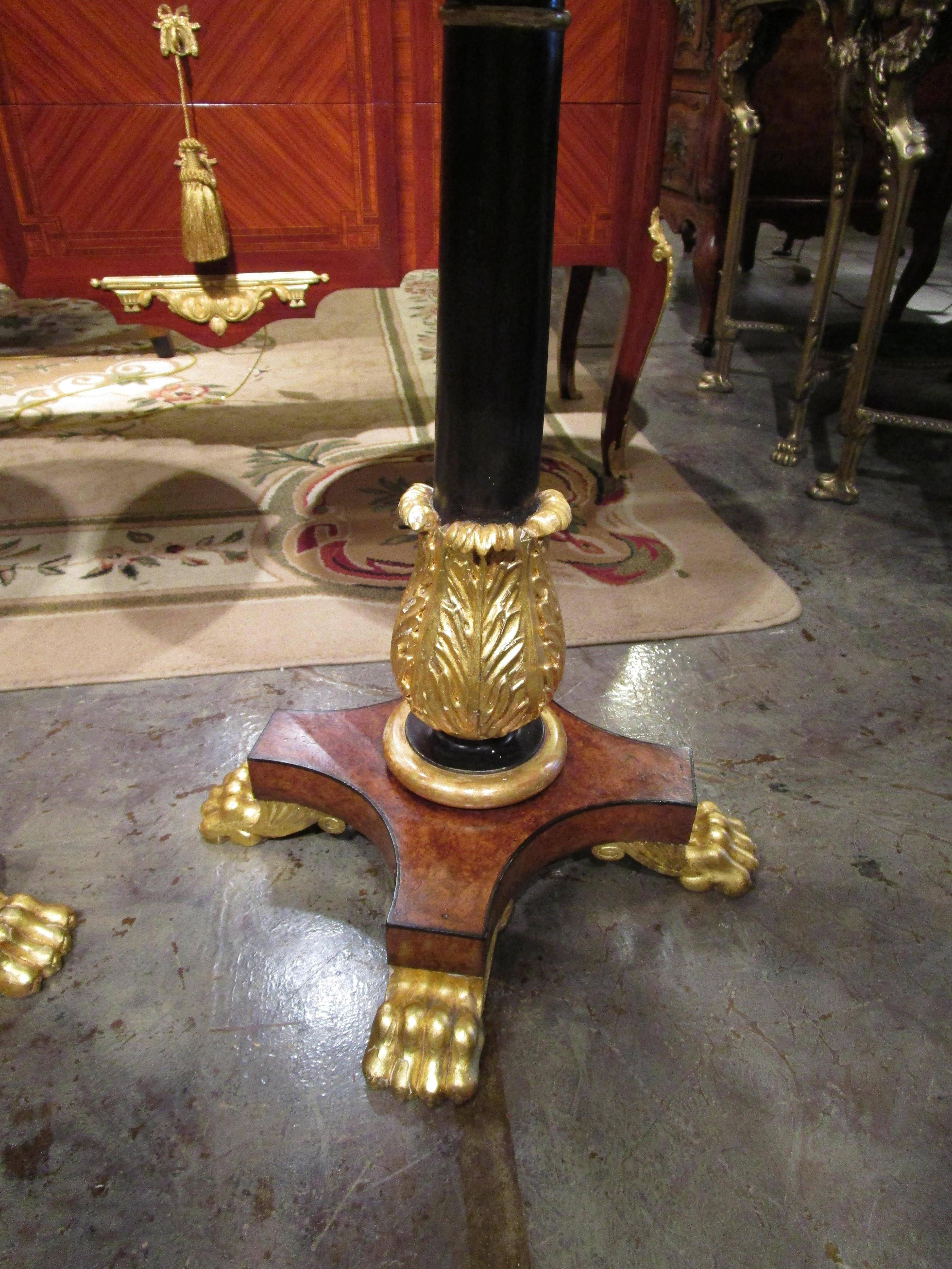 A very fine pair of Regency English Amboyna and ebonized pedestal base side tables with parcel gilt pawed feet. Brass inlay on the top.