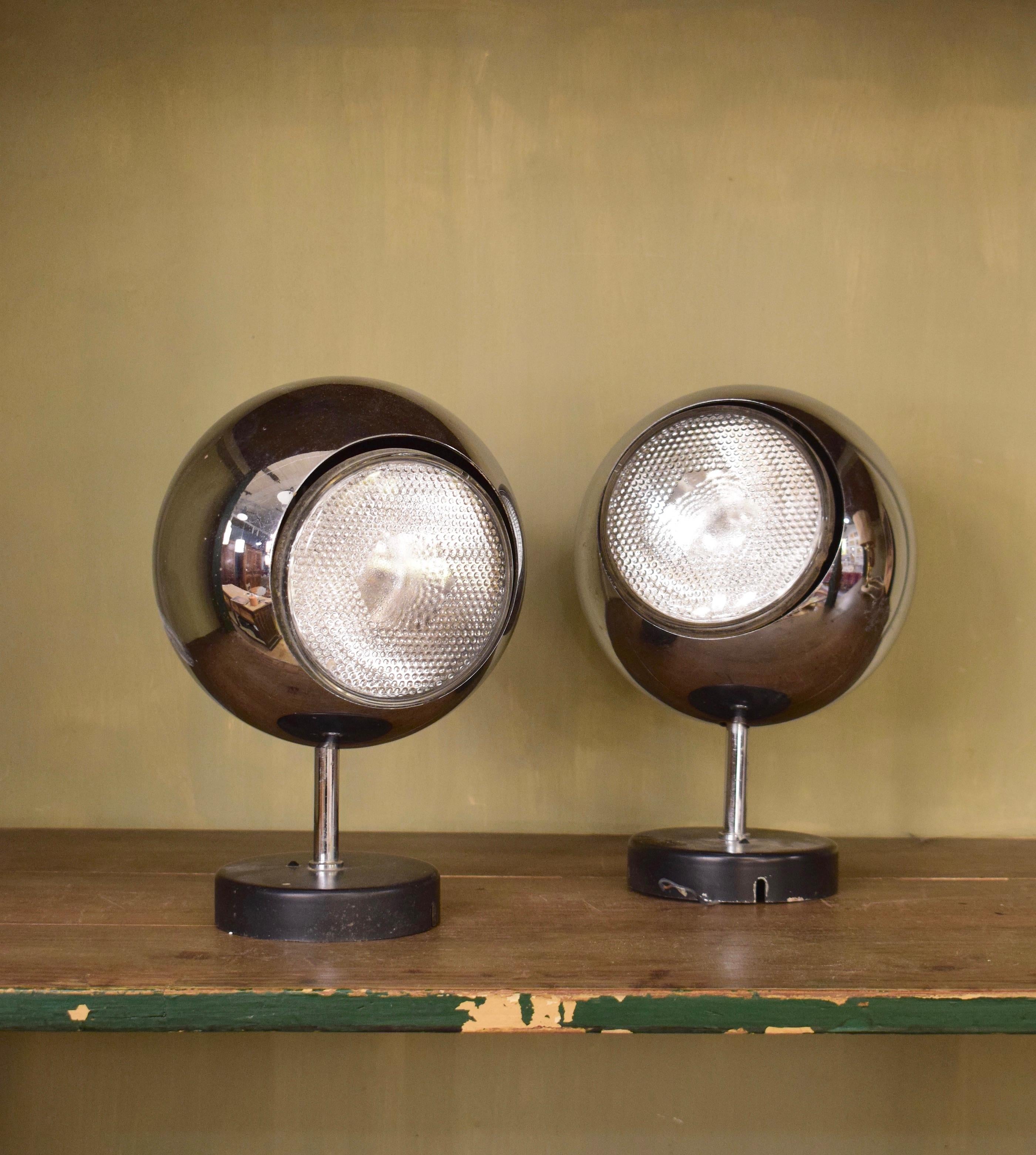 A pair of 1970s chrome ball desk lamps from the 1970s. They are in overall good condition with a little light scuffing. Each lamp can be adjusted to point in a desired direction. They are very playful objects.
