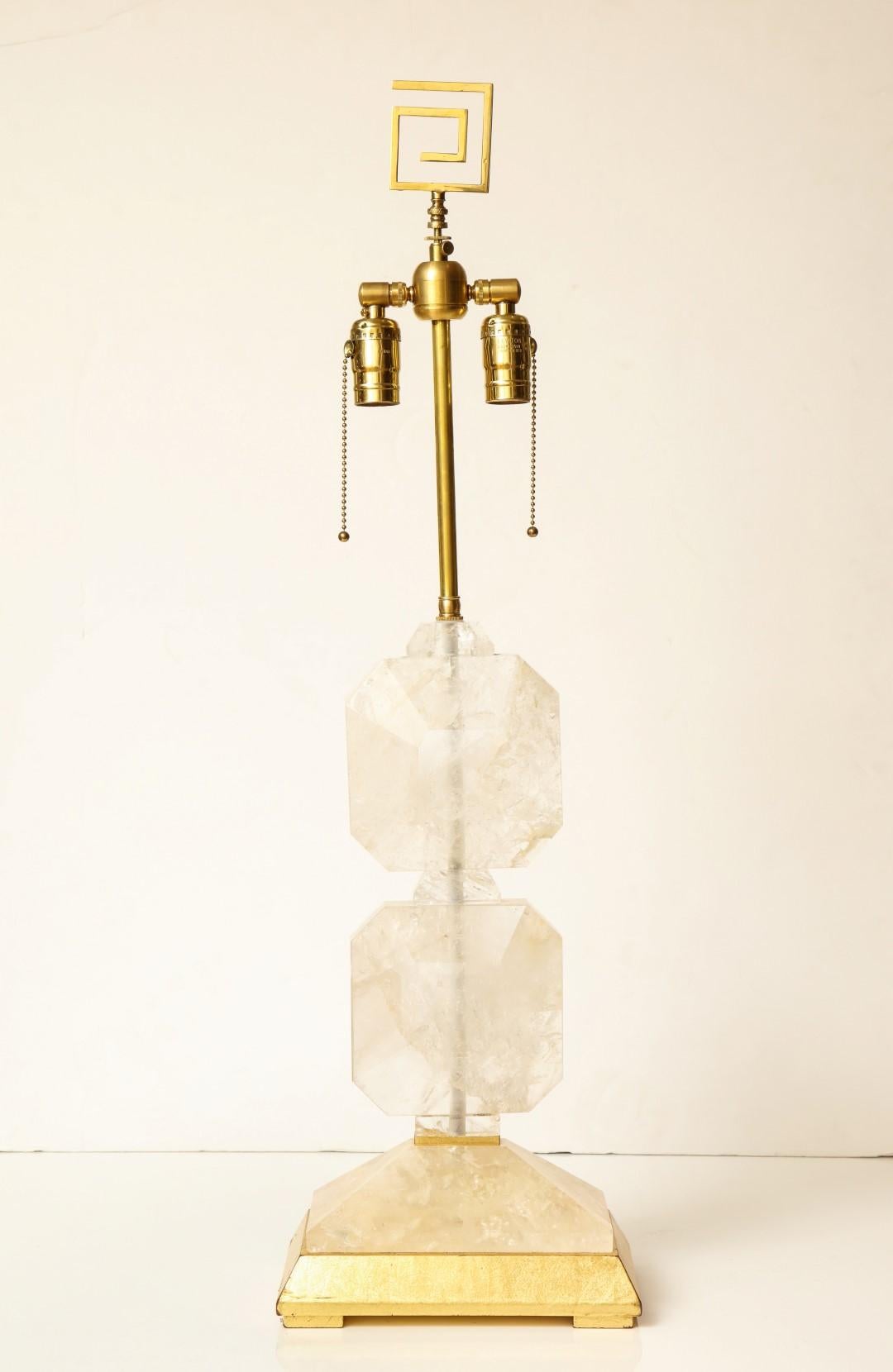 A pair of rock crystal table lamps with Greek key finial, giltwood base.