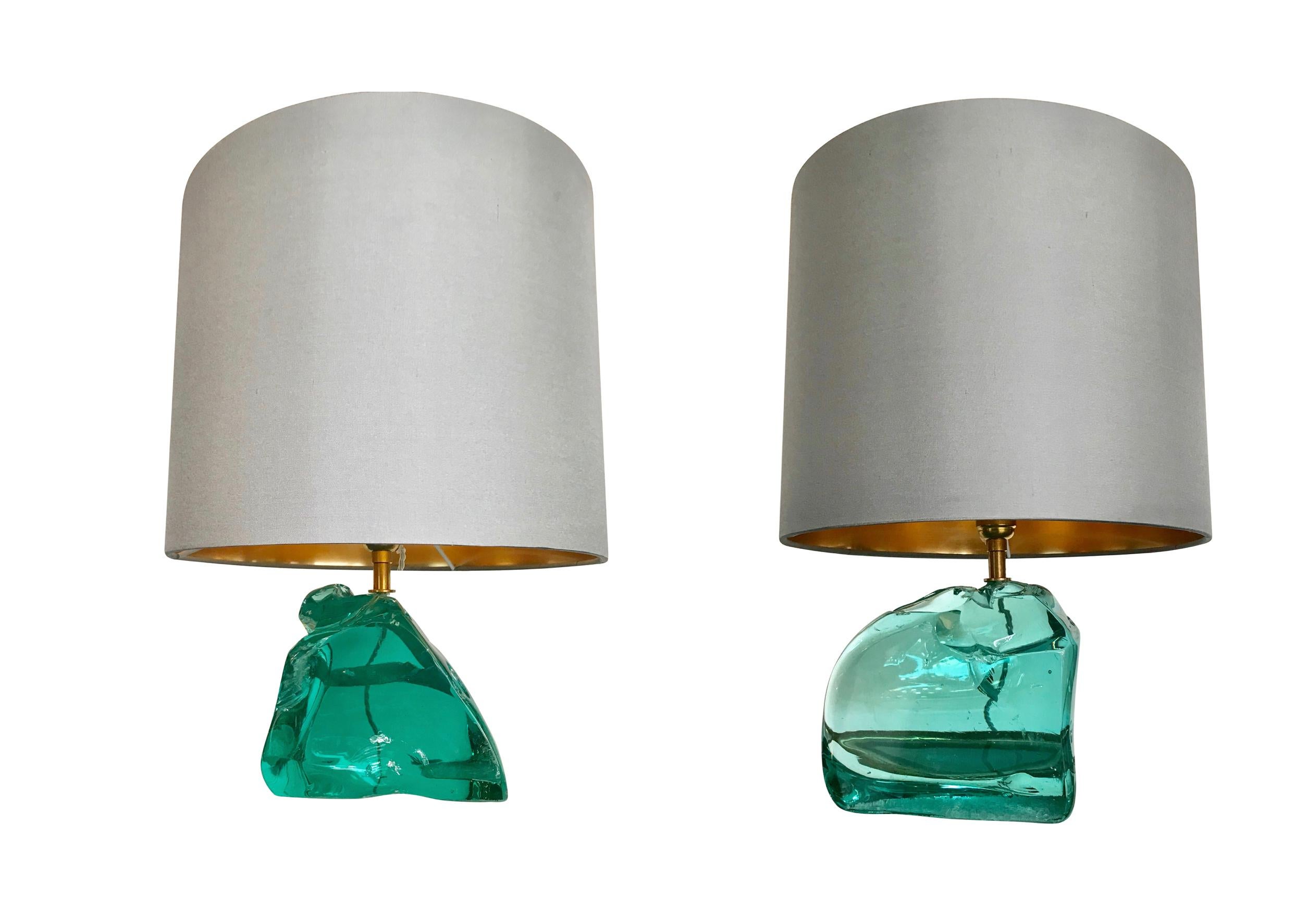 A pair of polished rock glass lamps with brass fittings in the style of Max Ingrand for Saint Gobain. Each base is made from a polished pieces of solid green glass which naturally has chips and contours like any natural material. With new bespoke