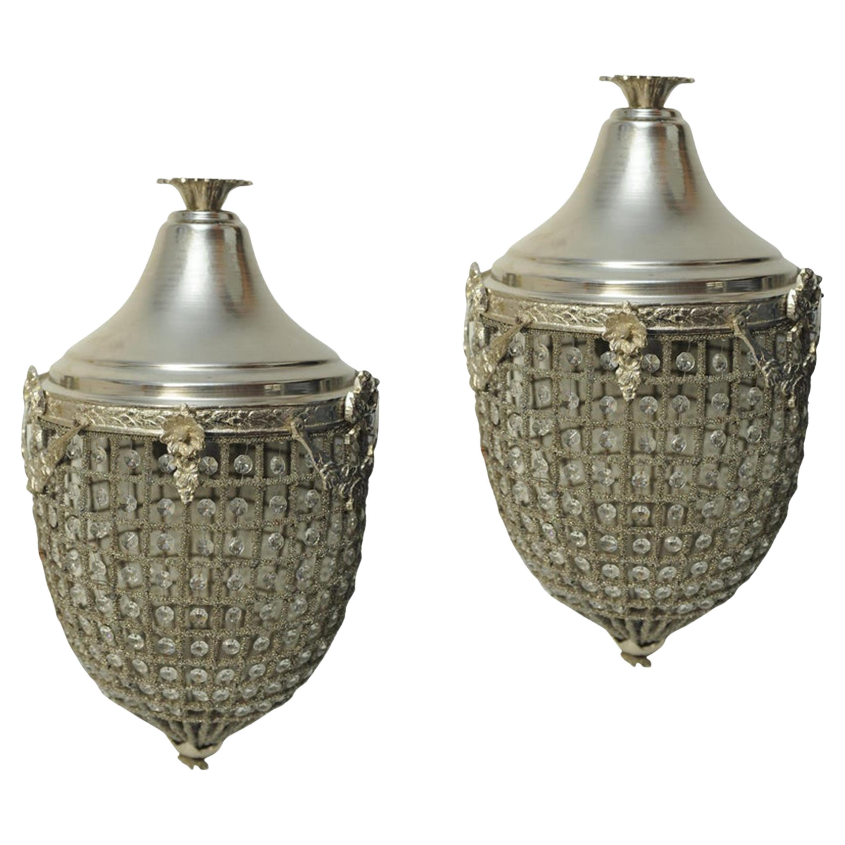 Paire de lustres en métal moulé de style Regency et Rococo avec panier en forme de gland, assortis. 

Les deux lustres sont décorés de sections en fil métallique, chaque section étant dotée d'un prisme attrayant qui capte la lumière lorsqu'il est