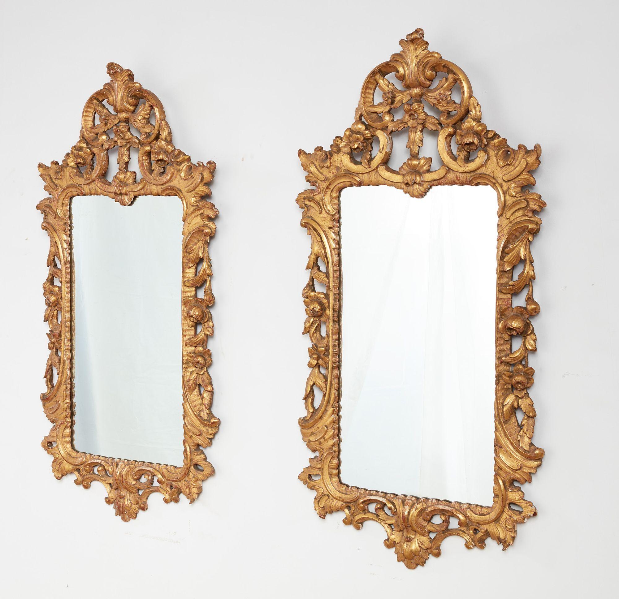 A pair of George III style giltwood rococo mirrors of rectangular form with gilt pierced foliate and C-scroll rocaille carving to crest, sides and base, having lovely worn water gilt surface.  