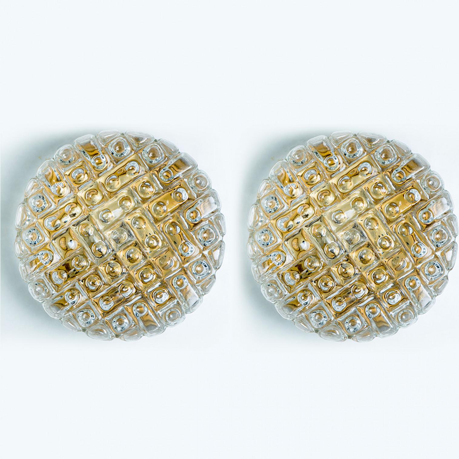 A pair of Clear colored bubble glass wall lights designed in the style of Helena Tynell around 1960-1970 in Europe, Germany. The rich textured bubbled glass gives a wonderful glow. The round glass is mounted on a gold colored metal back plate.

Can