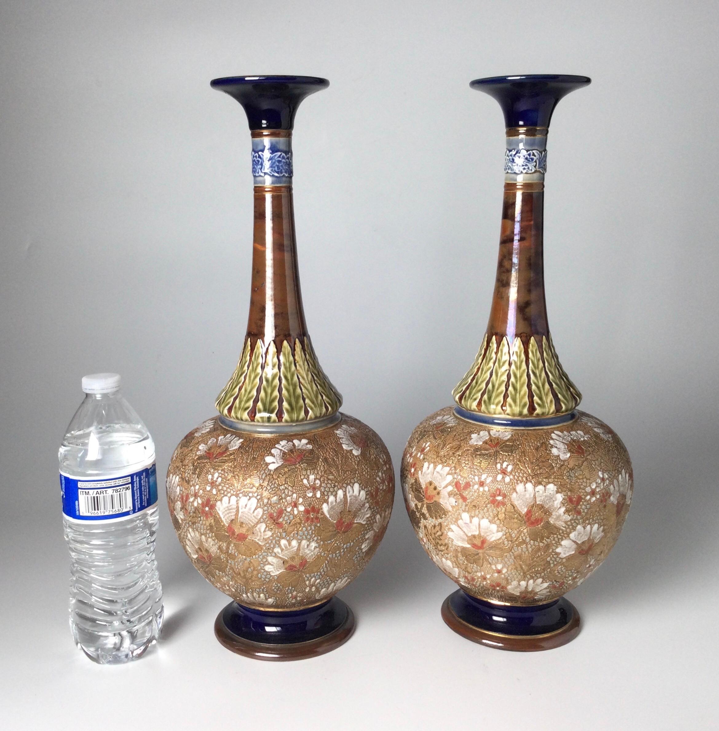 A pair of 16 inch tall Royal Doulton hand enameled art nouveau bases. The thin tapering necks with bulbous body with hand enameled decoration with cobalt blue glaze accents. Marked on bottoms with the makers mark, Circa 1900.