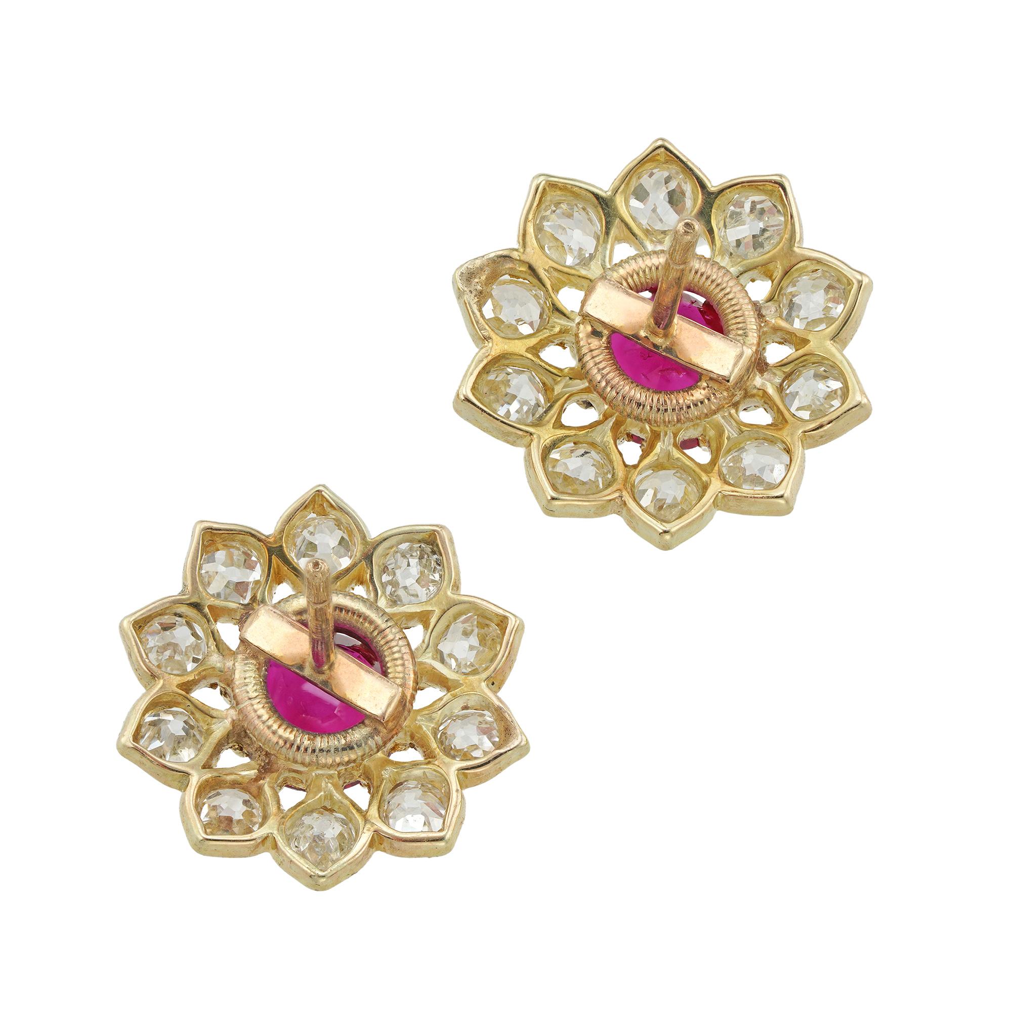A pair of ruby and diamond cluster stud earrings, each centrally claw-set with a round faceted ruby, the rubies weighing a total of 1.09 carats accompanied by GCS Report stating to be of Burmese origin with no indication of heating, surrounded by