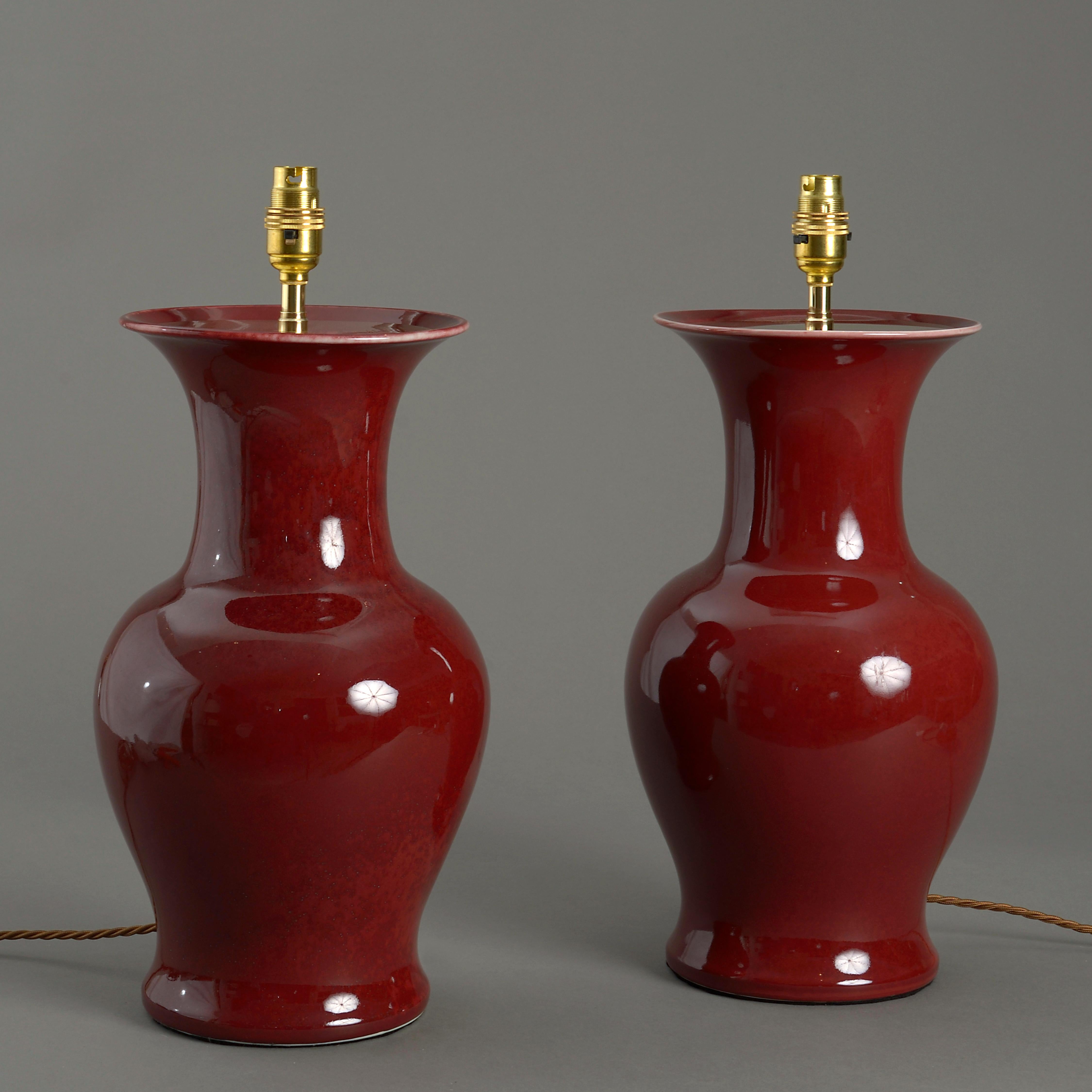 A pair of red sang de boeuf glazed porcelain vases of generous form, having trumpet form necks and now mounted as lamp bases.

Dimensions refer to size of vase excluding electrical components.

Shades available to purchase separately.

  