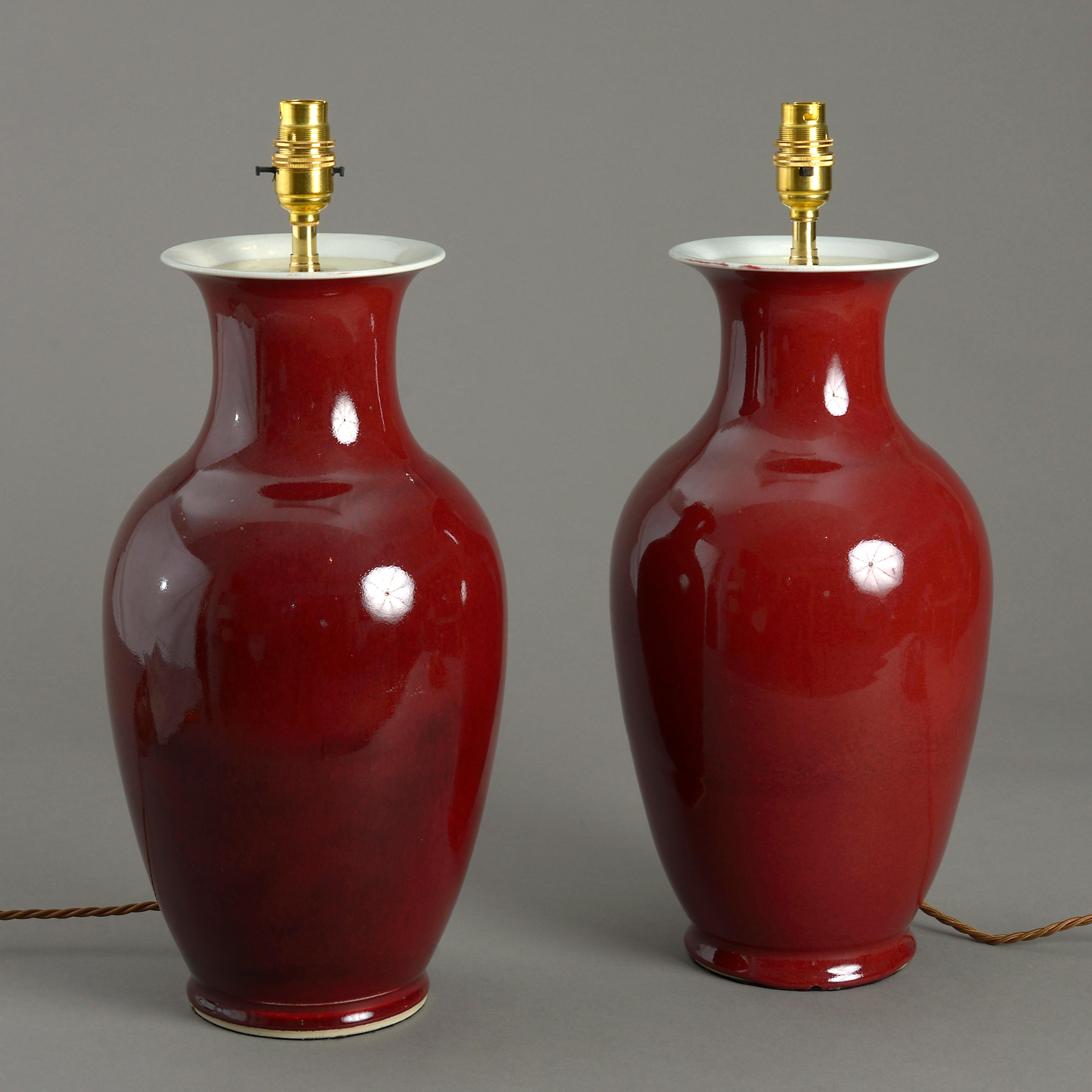 A pair of sang de boeuf glazed porcelain vases, of baluster form, now wired as table lamps.

Dimensions refer only to height of vases excluding electrical components.
