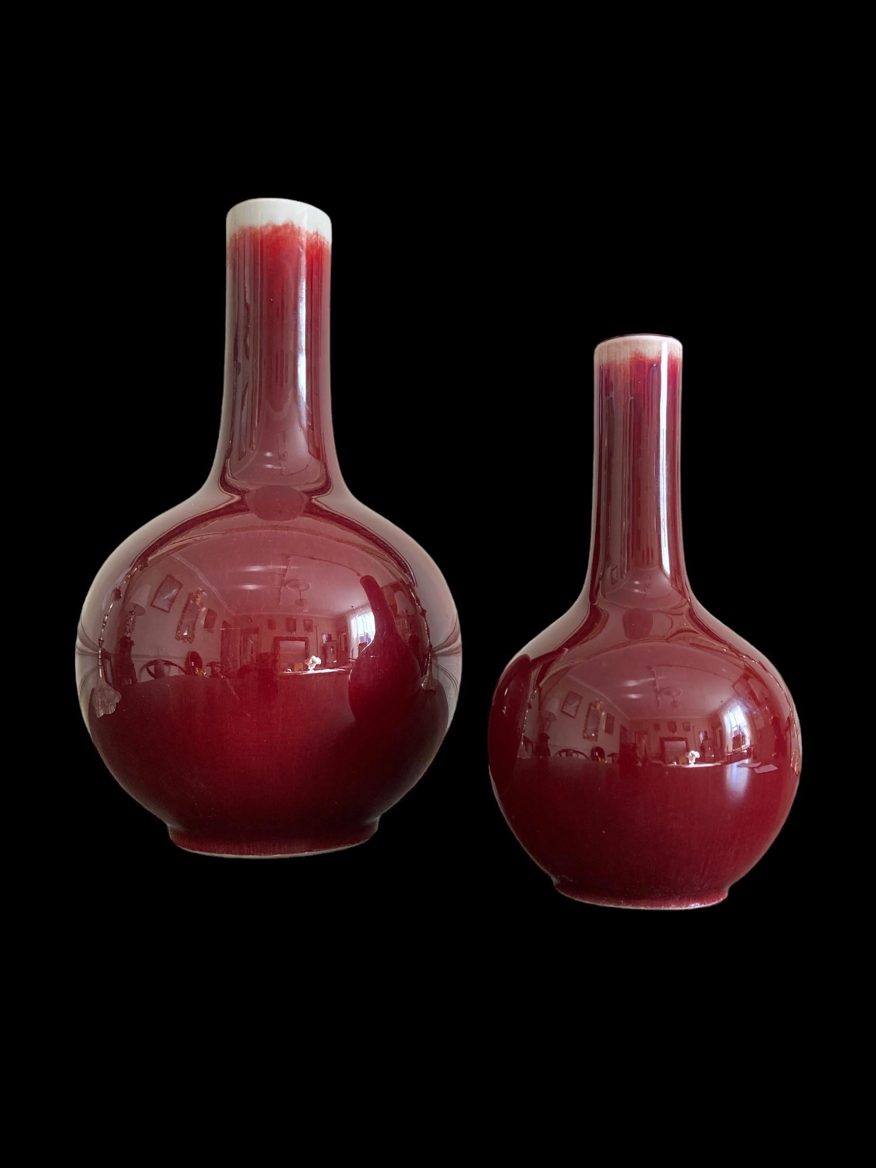 A beautiful pair of Chinese red glazed long neck Sang De Bouef flambe flask vases and varying heights.

Larger vase 23.5cm x 14cm
Smaller vase 16.5cm x 9cm
