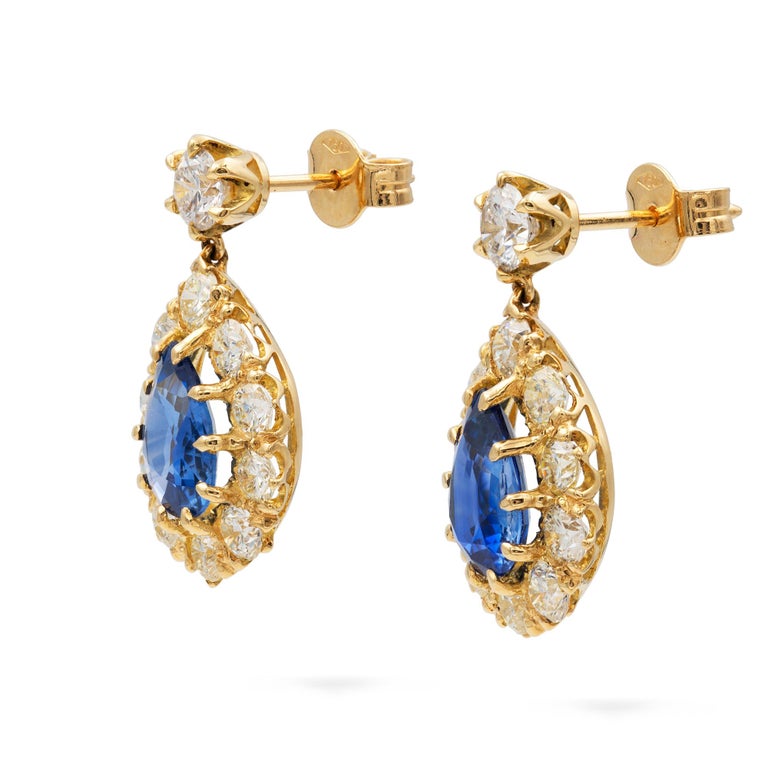 A pair of sapphire and diamond drop earrings, each with a round brilliant-cut top, suspending a pear-shaped sapphire surrounded by ten round brilliant-cut diamonds, the sapphires weighing 3.27 carats in total, the diamonds estimated to weigh 2.5