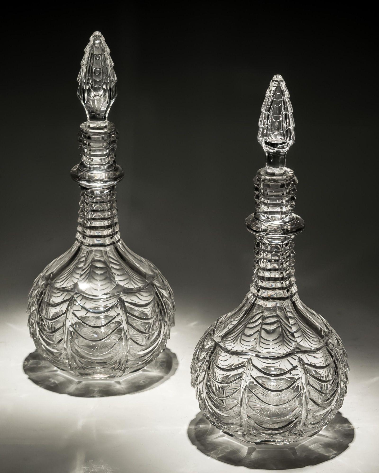 A pair of scale cut shaft and globe decanters with matching spire stoppers.