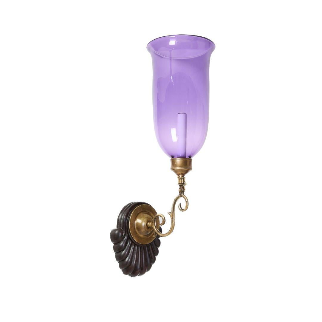 Paire de plaques de fond de style géorgien en acajou sculpté à la main, avec garnitures d'applique en laiton patiné et abat-jour évasé en forme d'ouragan violet. Electrifiée avec une douille à base candélabre par applique.