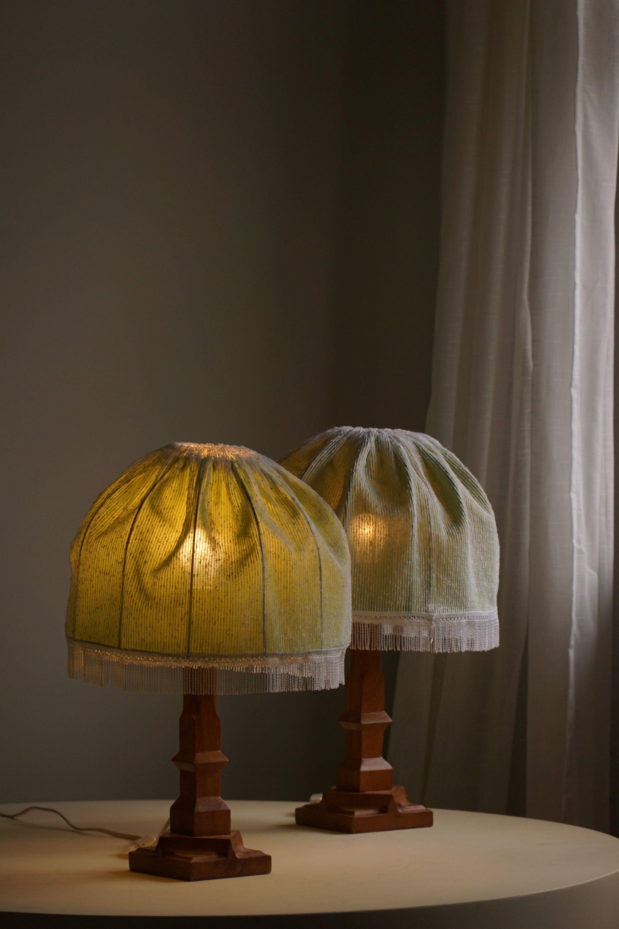 A pair of organic shaped wooden teak table lamps with some green silk shades. Handcrafted in Scandinavia by an unknown cabinetmaker in the ca 1970s. An intriguing shape that will complement many interior styles. A modern, classic, Scandinavian or an