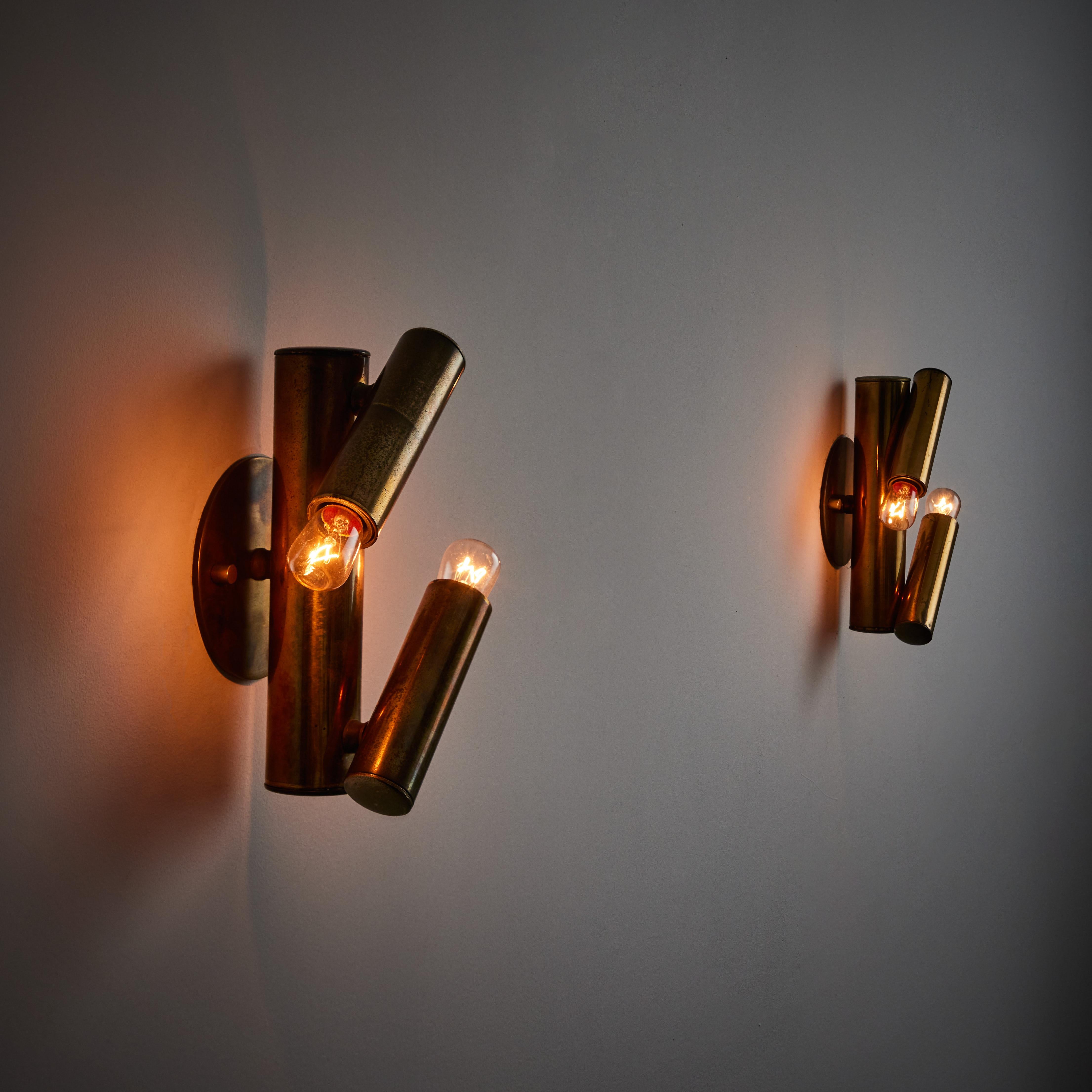 Pair of sconces by Gaetano Sciolari. Manufactured in Italy, circa 1950s. A trio of all brass pipes make up these elegant and minimal scones. Aged brass is at full show throughout this pair. Each light holds two E14 sockets, adapted for the US. We