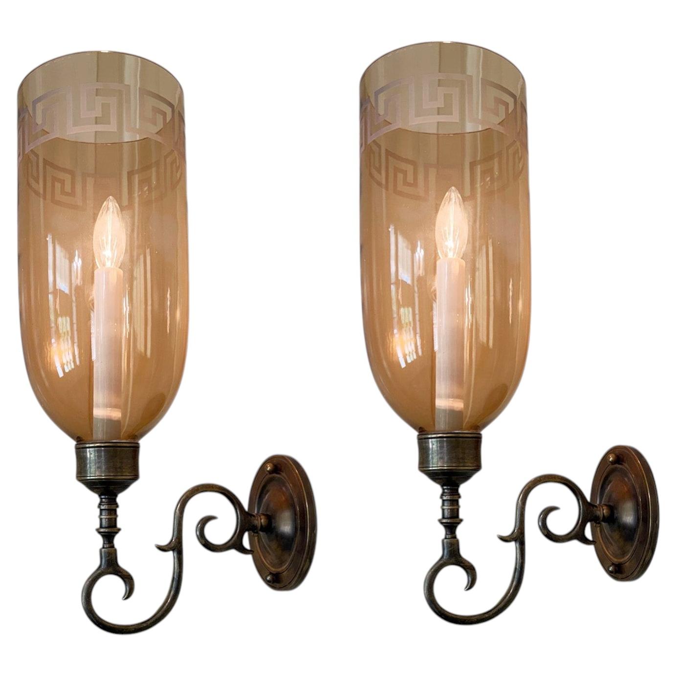 A Pair of Sconces with Amber Etched Hurricane Shades