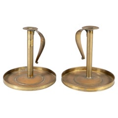 A pair of Scottish School Arts & Crafts brass candlesticks w circular drip trays