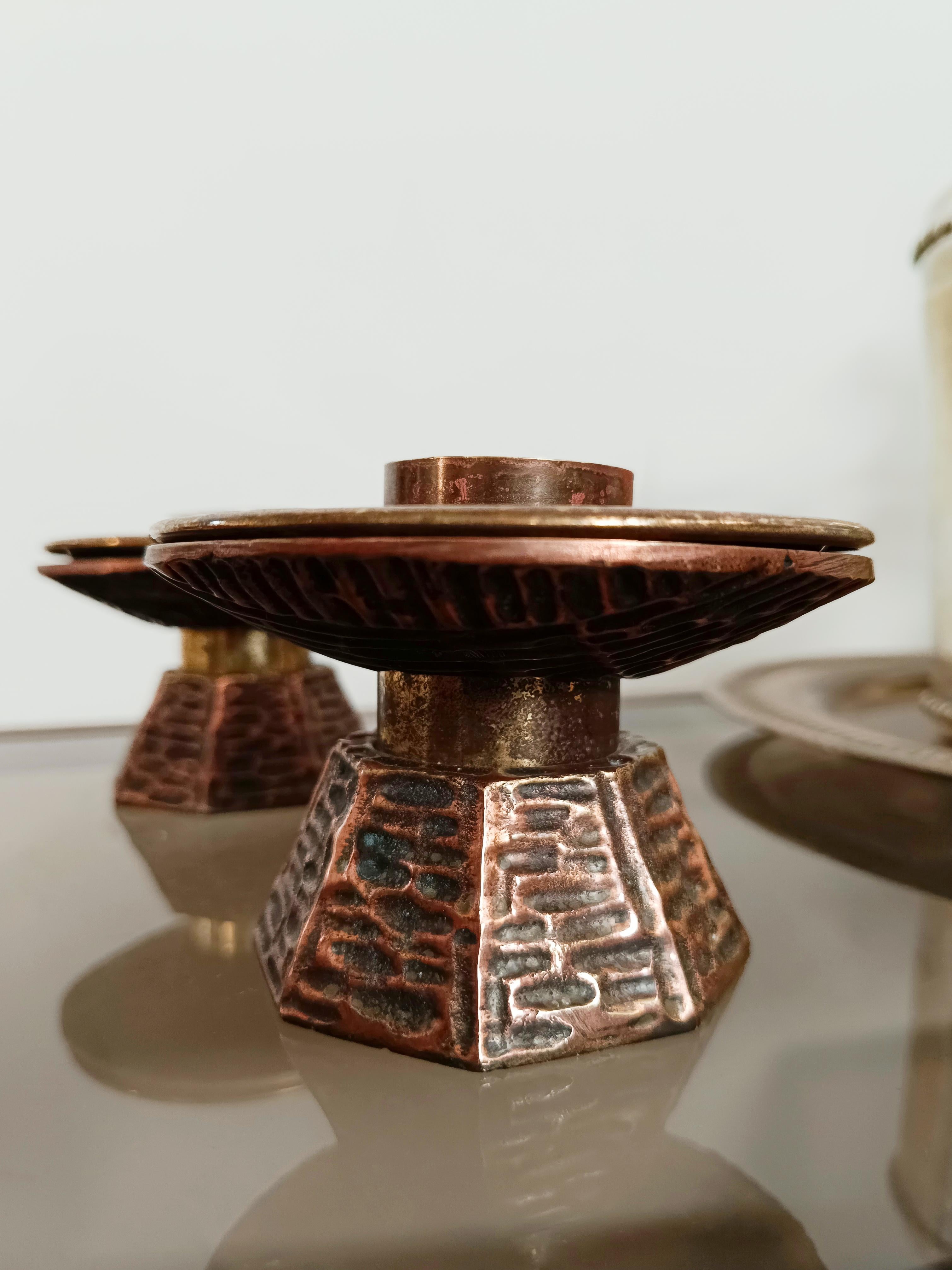 A pair of sculptural candlesticks probably made in Italy between the 60s and 70s.
The irregular texture created like a bas-relief by small and irregular signs engraved in the surface, recalls the work of the artist Arnaldo Pomodoro and creates