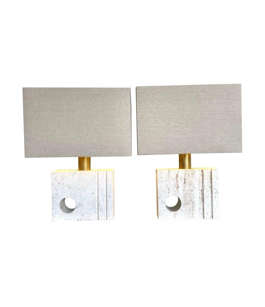 A pair of sculptural Italian 1970s Travertine lamps by Fratelli Mannelli, each with hole and groove designs. Rewired with new brass fittings, antique cord flex and switch and new bespoke natural linen shades