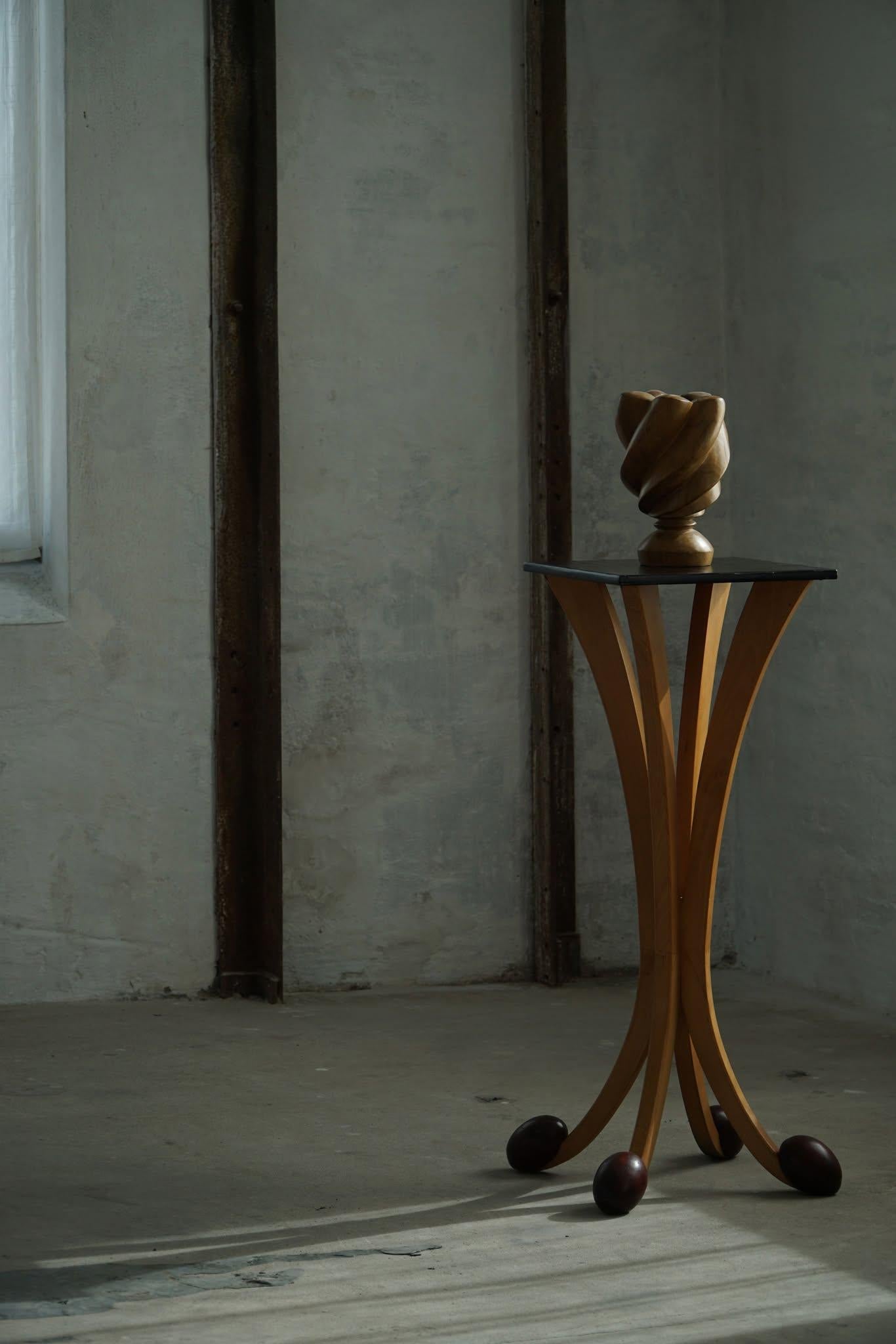 Una coppia di piedistalli scultorei degli anni '80 che riflettono l'estetica audace e giocosa del design postmoderno francese. Questi stand unici sono caratterizzati da supporti in legno elegantemente curvati che si aprono a ventaglio verso