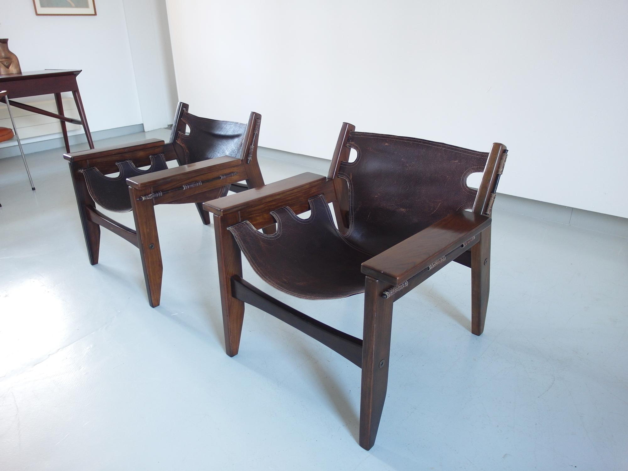 Beautiful pair of Sergio Rodrigues Kilin lounge chairs for Oca, Brazil, 1973 in solid Imbuia wood. The design of these exceptional lounge chairs was inspired by tropical hammocks and Campaign furniture. This version -with bolts- was produced by Oca