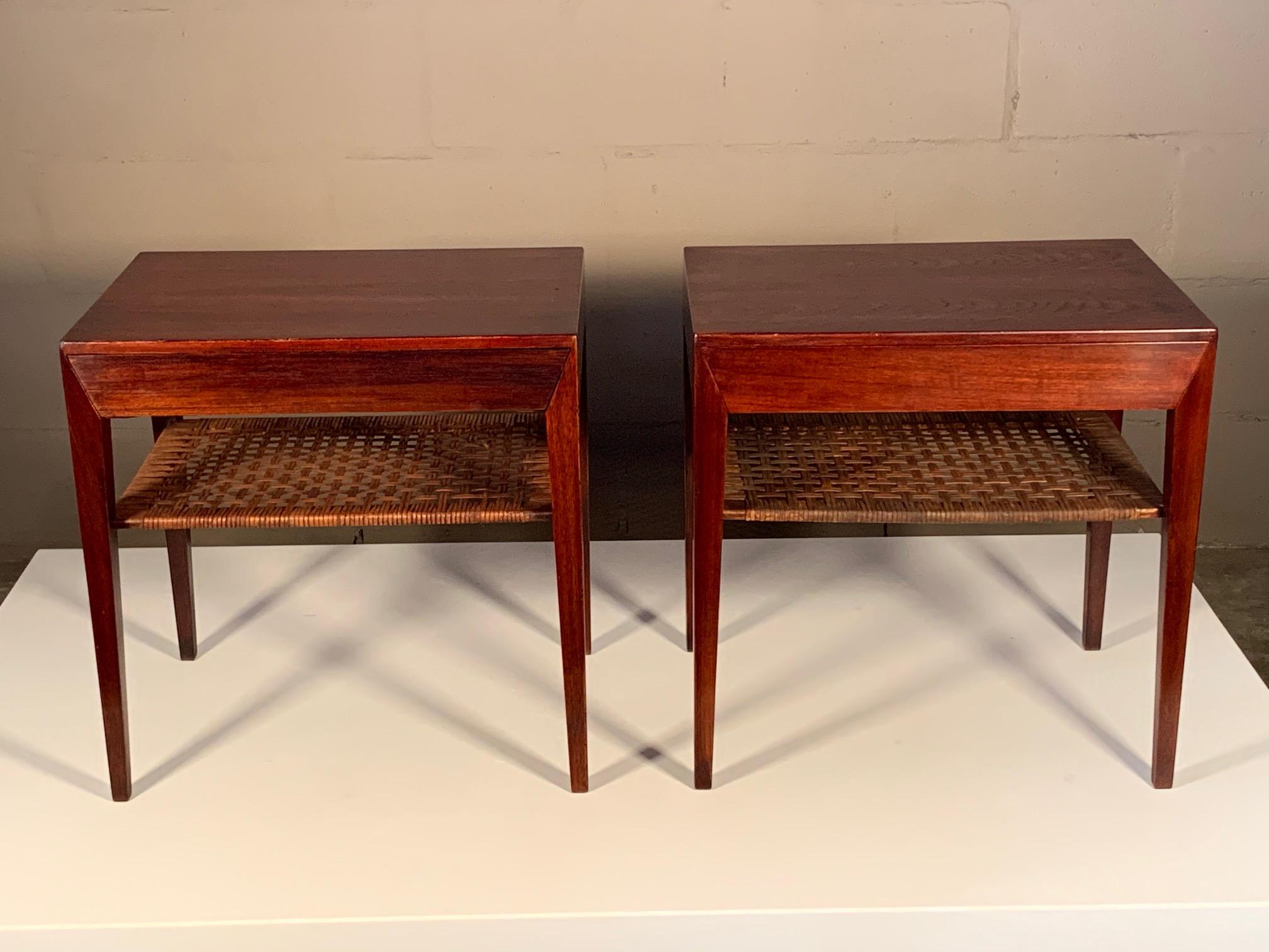 A pair of Classic nightstands or side tables by Severin Hansen for Haslev (partial label present). Teak with custom finish, pullout / pull-out drawer and caned lower shelf.