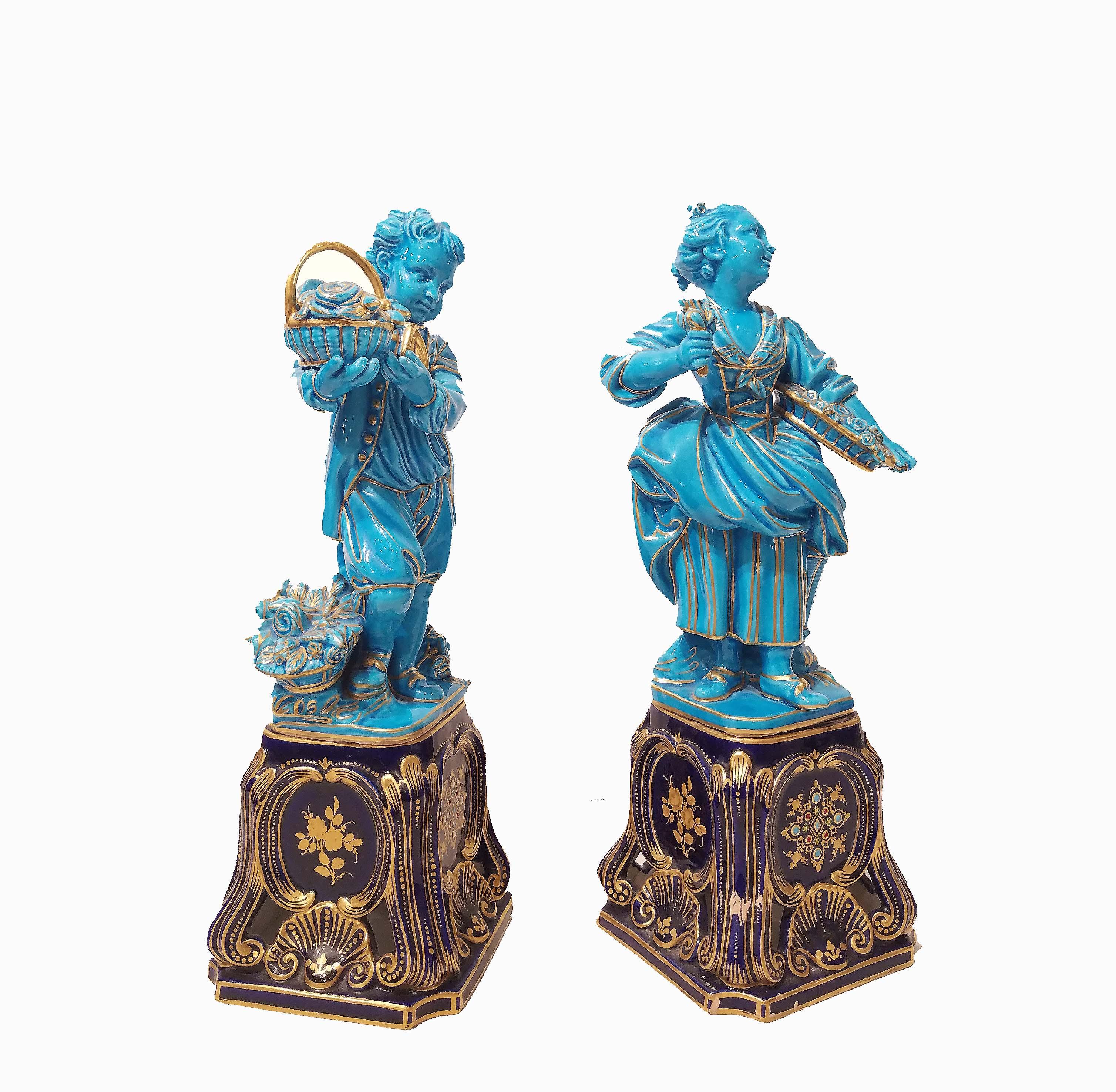 A pair of French Sevres style turquoise-glazed figures of a boy and girl, late 19th century
After a model by Falconet.
Both holding a basket of flowers, the details picked out in gold, on a cobalt blue jeweled porcelain decorated bases.
The girl