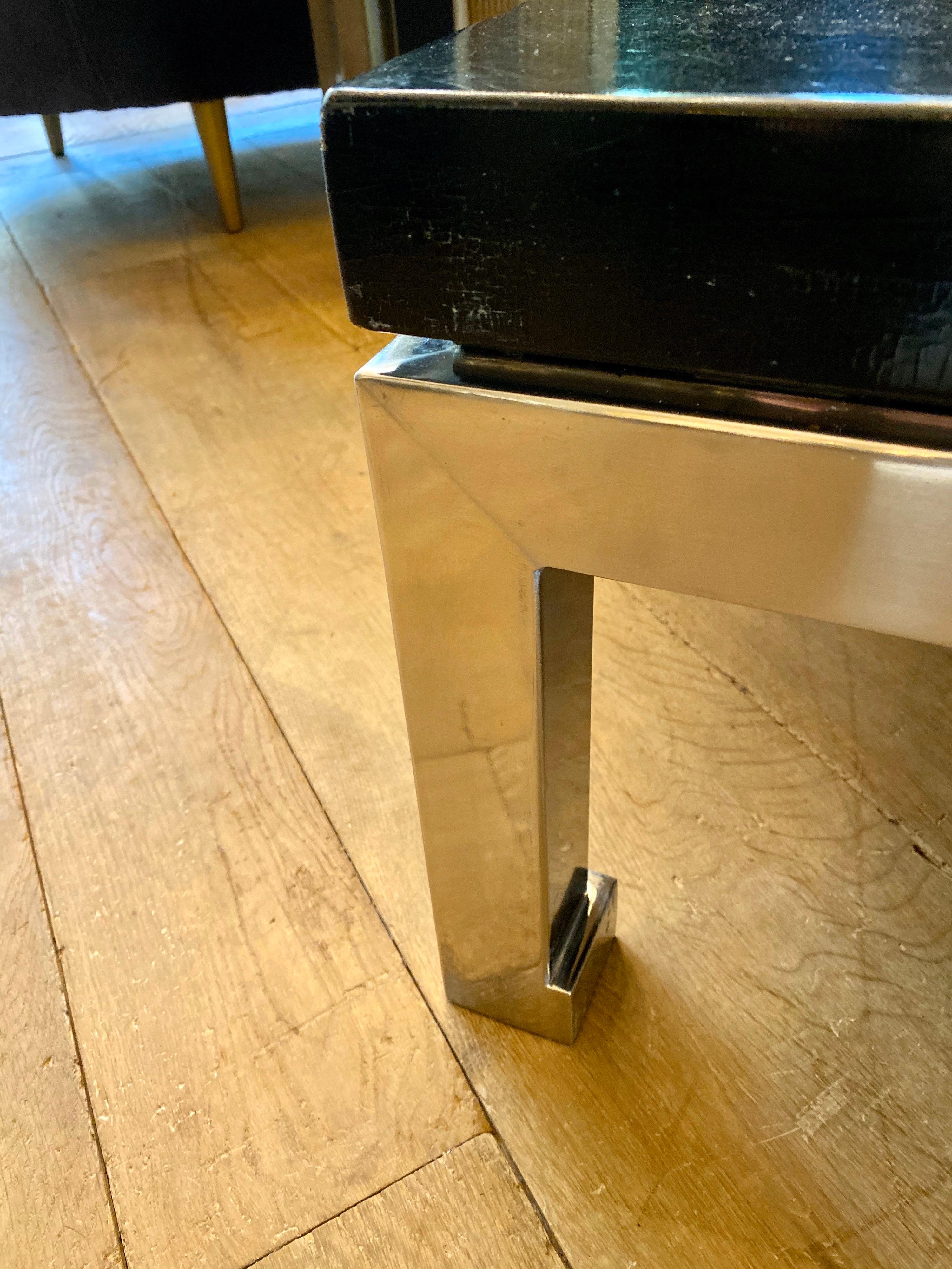 A large and substantial pair of side or end table in brushed steel with crackle finished black lacquered tops. A matching coffee table is also available. By Guy Lefevre for Maison Jansen, Paris.