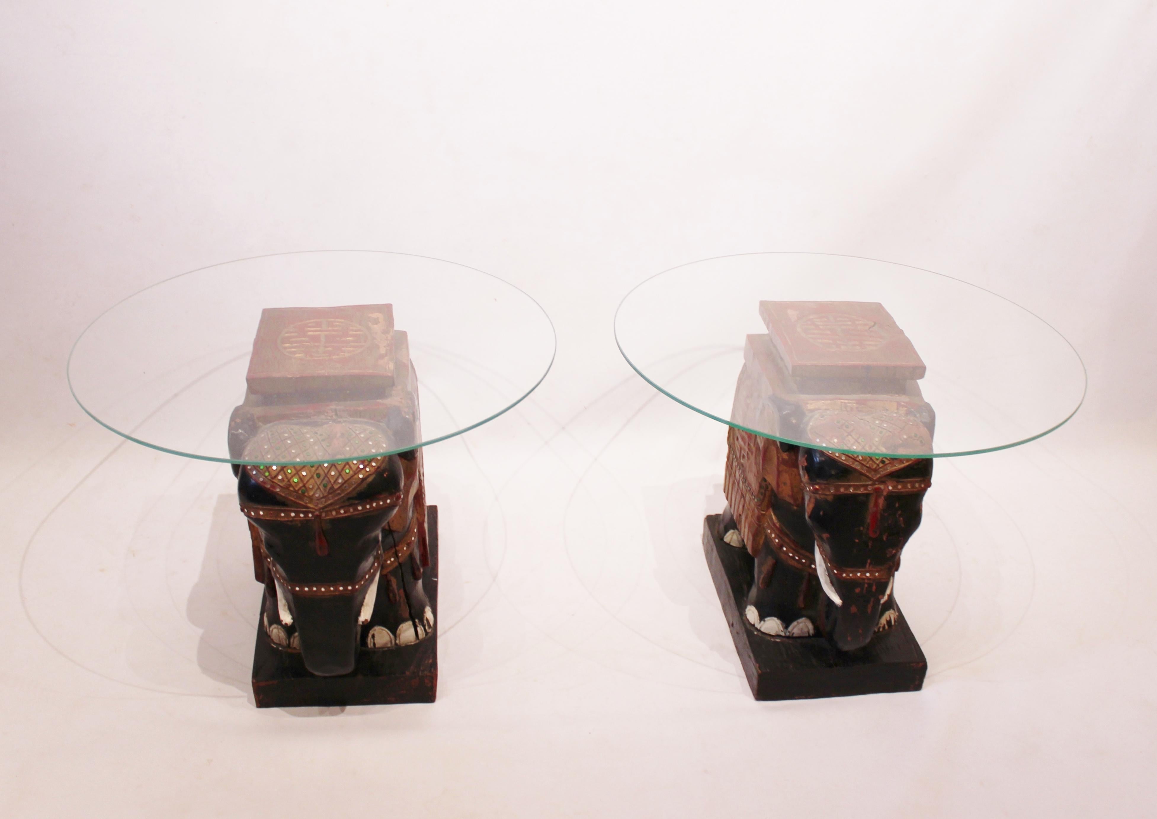 Un par de mesas auxiliares con placas de cristal y bases de elefante chino de madera pintada y patinada original de hacia la década de 1880 es un hallazgo verdaderamente único y cautivador.

La combinación de las placas de cristal y las bases de