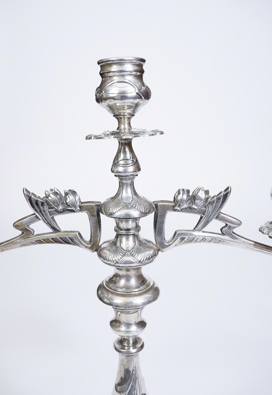Diese beiden auffälligen Jugendstil-Kandelaber aus Silber des berühmten Wiener Silberschmieds Eduard Friedman sind ein Beispiel für die organische Dynamik und skulpturale Eleganz dieser Zeit.

Jeder Kandelaber steht auf drei gezackten, stilisierten
