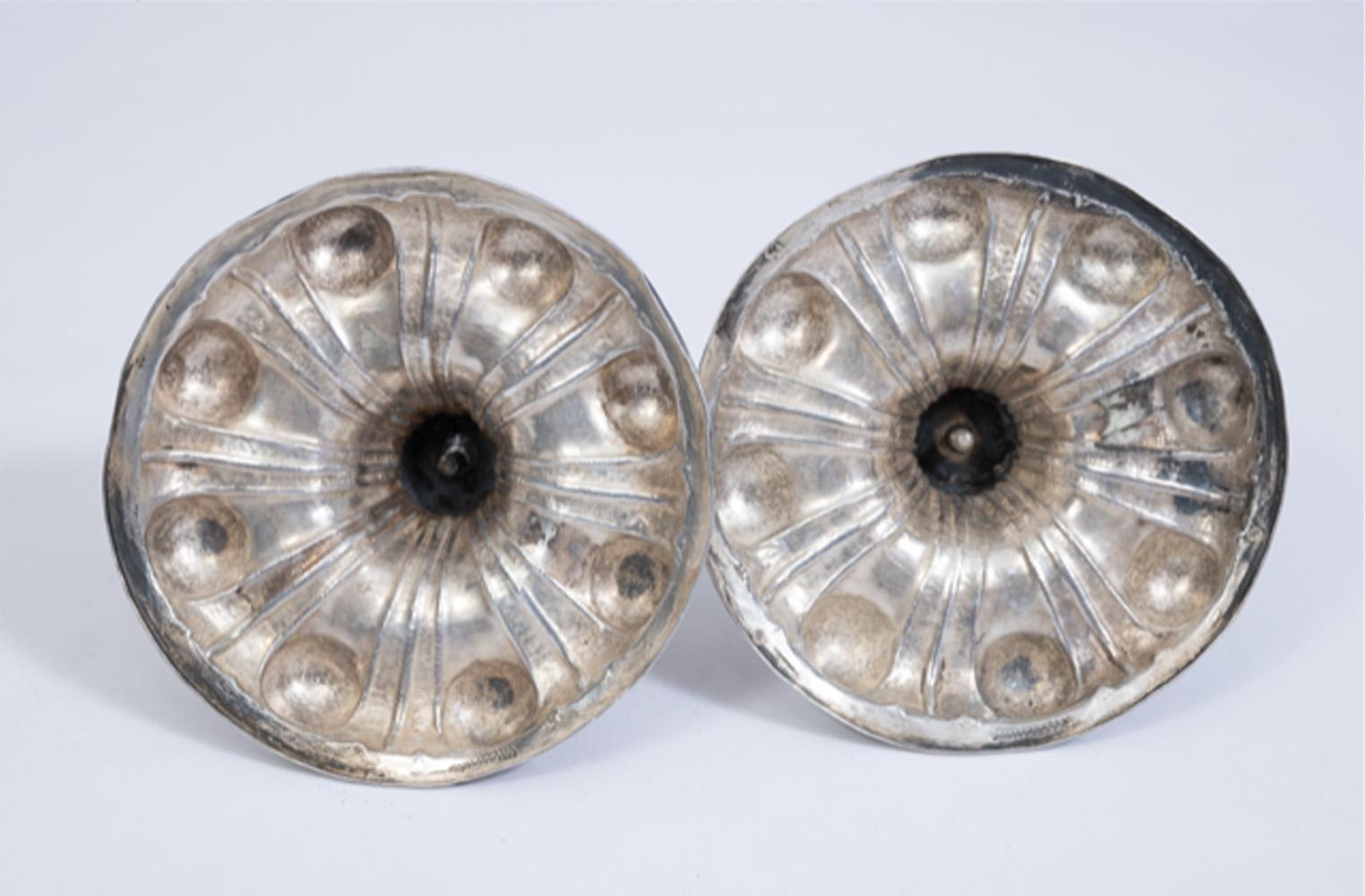 Un'elegante e raffinata coppia di candelieri in argento dei primi del XVIII secolo, realizzati a Roma intorno al 1720, che mostrano la sensibilità barocca e la maestria nella lavorazione dei metalli caratteristica degli argentieri romani