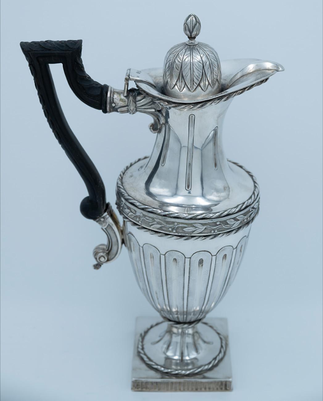 An elegant and richly detailed pair of silver pitchers, crafted in Prague around 1800, exhibiting both technical refinement and a distinct neoclassical aesthetic, emblematic of Central European silverwork at the turn of the 19th century.

Each