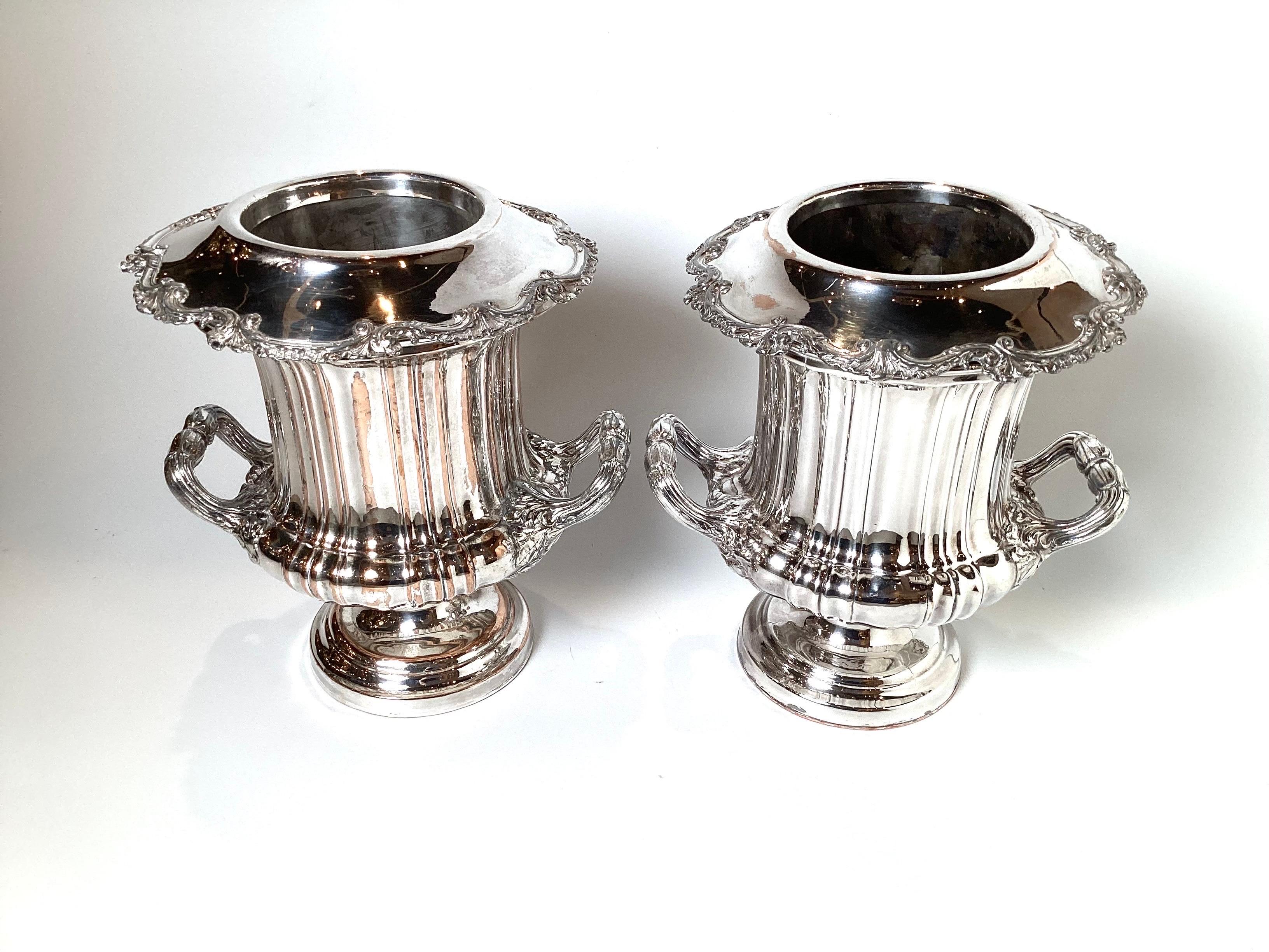 A fine pair of silver plate on copper Champagne coolers. The Campana urn form with liners, each in three parts. There is copper bleed through the silver plate, but still very useful and elegant.
