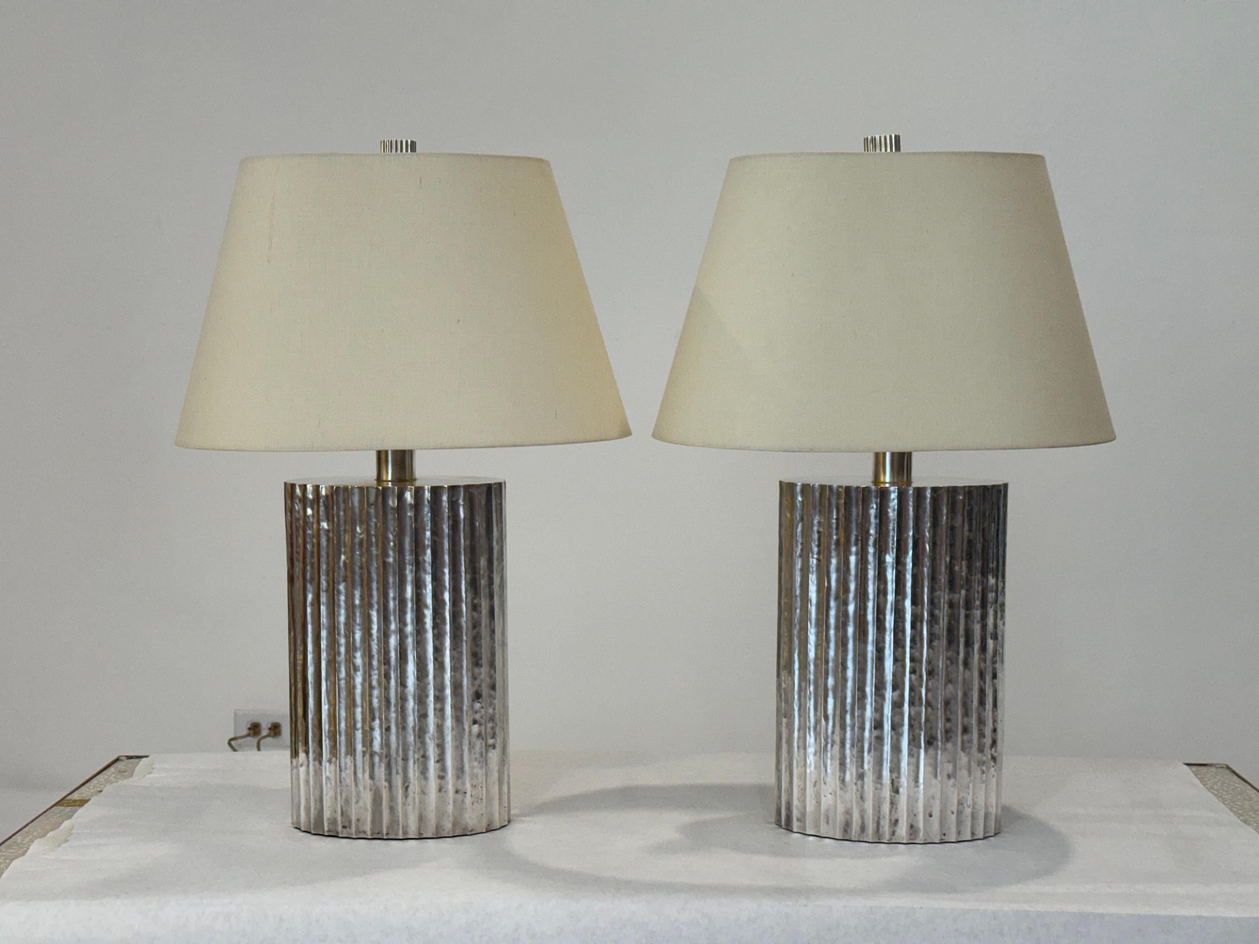 This striking pair of silver plated fluted flask lamps was designed by renowned artist Robert Kuo for McGuire Furniture. Robert Kuo began collaborating with McGuire during the 1990s, combining his traditional repoussé metalwork techniques with