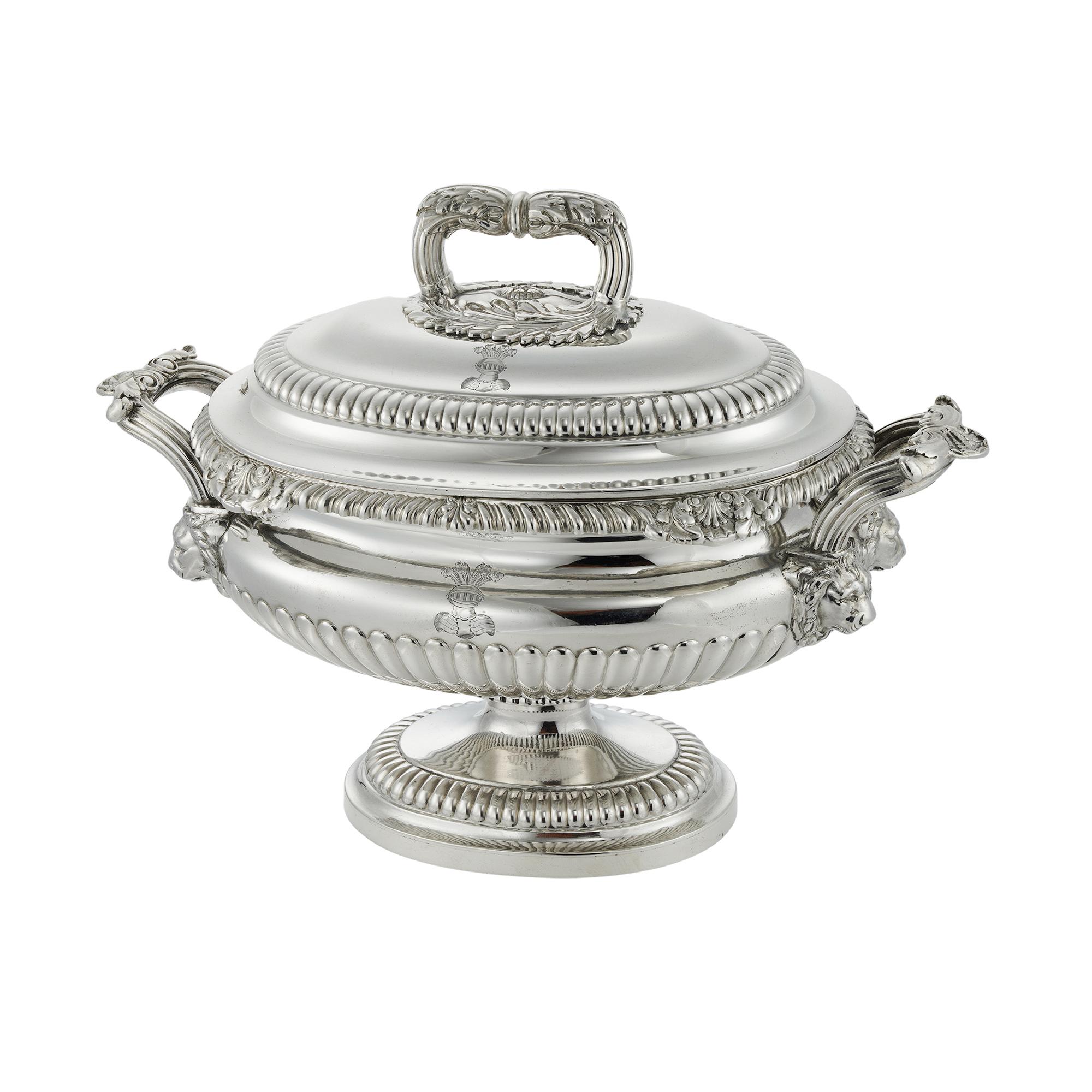 A pair of George IV oval silver sauce boats and covers, the half fluted body, with gadroon and shell mounts, two fluted, shell and lions head handles, on oval partly gadrooned foot, the cover also partly gadrooned, body and cover crest engraved,