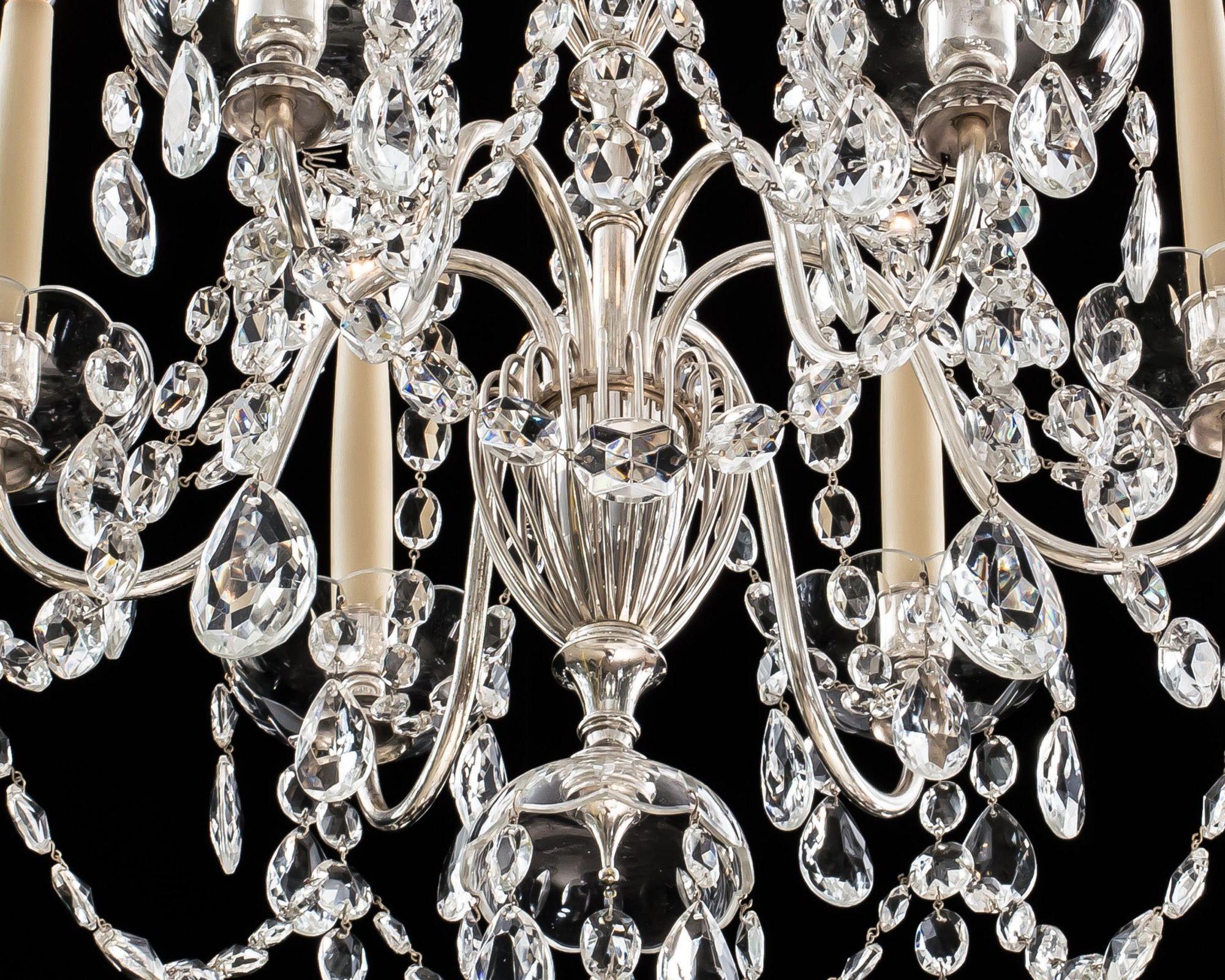 The baluster stem centred by a spiral urn and corresponding canopy, with cascading chains. The candle branches are swaged with drapes and fitted with drop hung pans.