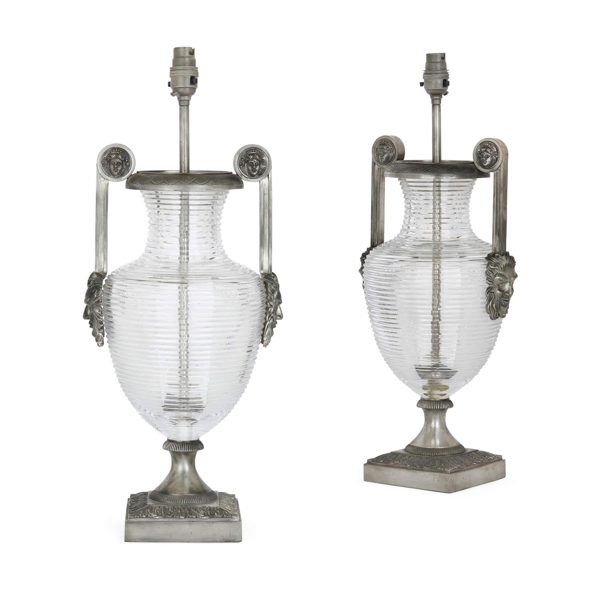 A pair of silvered-bronze and cut-glass urn lamp bases in the French Empire style
American, 20th century
Measures: Height 55cm, width 22cm, depth 18cm

These fine lamp-bases, shaped like Classical amphorae, and combining a modern feel with a