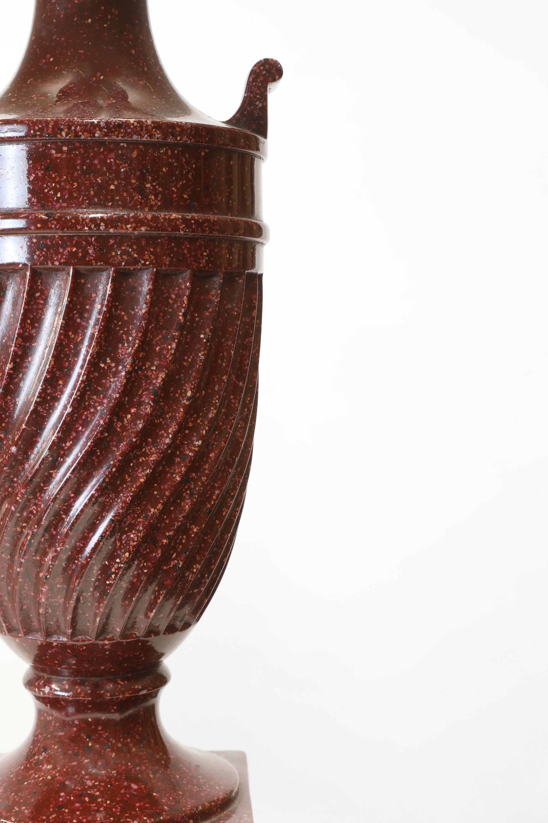 Paire classique de lampes de table en porphyre simulé rouge du 20e siècle. Chacune modélise une élégante forme d'urne cannelée spiralée.

 Le porphyre est une pierre dure et rare, de couleur rouge pourpre, qui était très prisée dans l'Antiquité pour