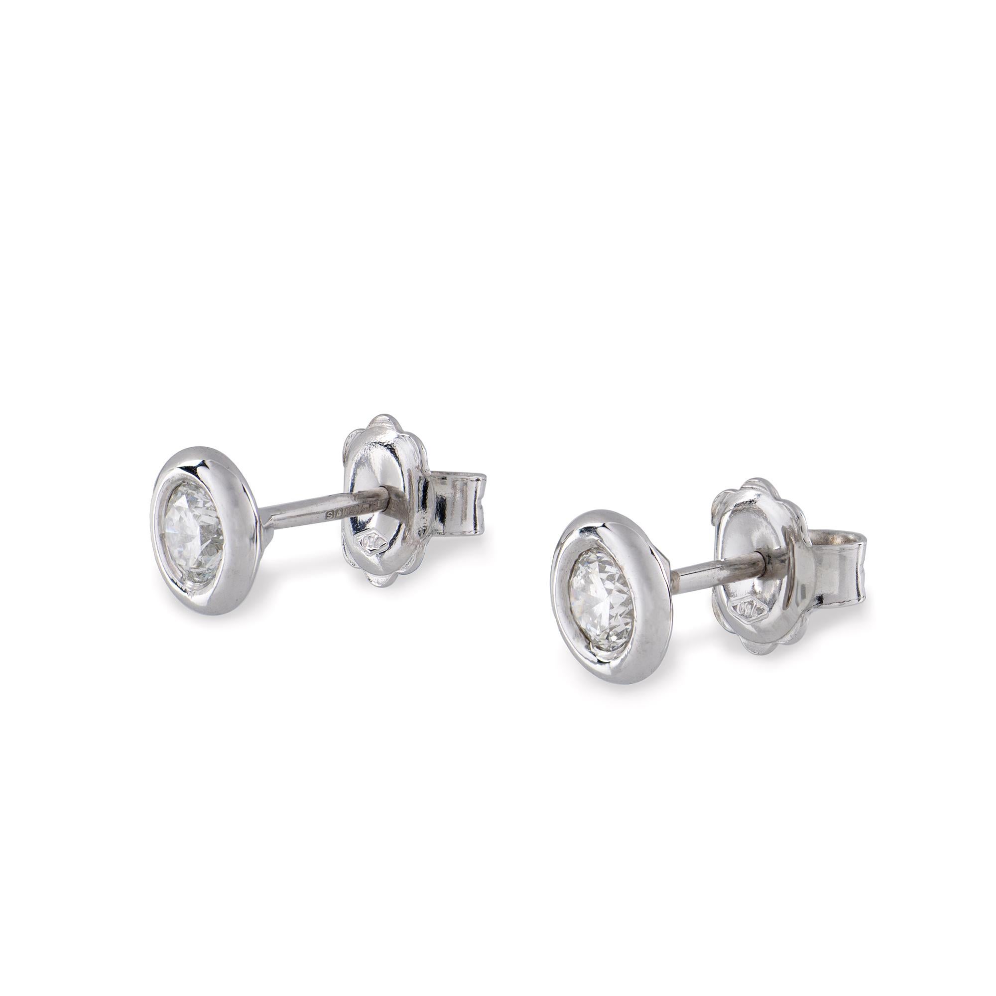A pair of single stone diamond stud earrings, the round brilliant-cut diamonds weighing a combined total of 0.72 carats, each set to a white gold rubover collet, with a post and butterfly fitting closure , hallmarked gold 750 , London, 2017, gross