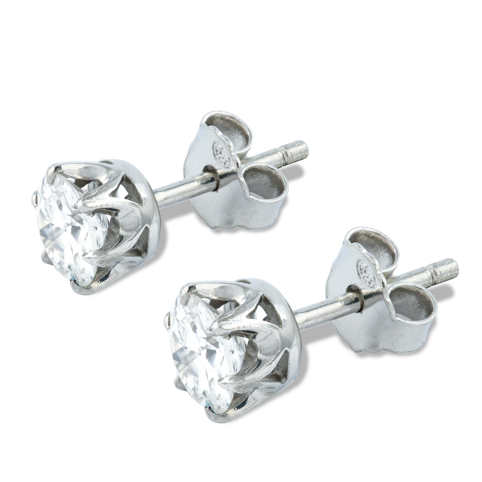 A pair of single stone diamond stud earrings, the round brilliant-cut diamonds weighing 0.73 and 0.74 carats, each set to a platinum rex-collet to a peg and C-scroll fitting, hallmarked platinum, London 2017, made by Bentley & Skinner, measuring