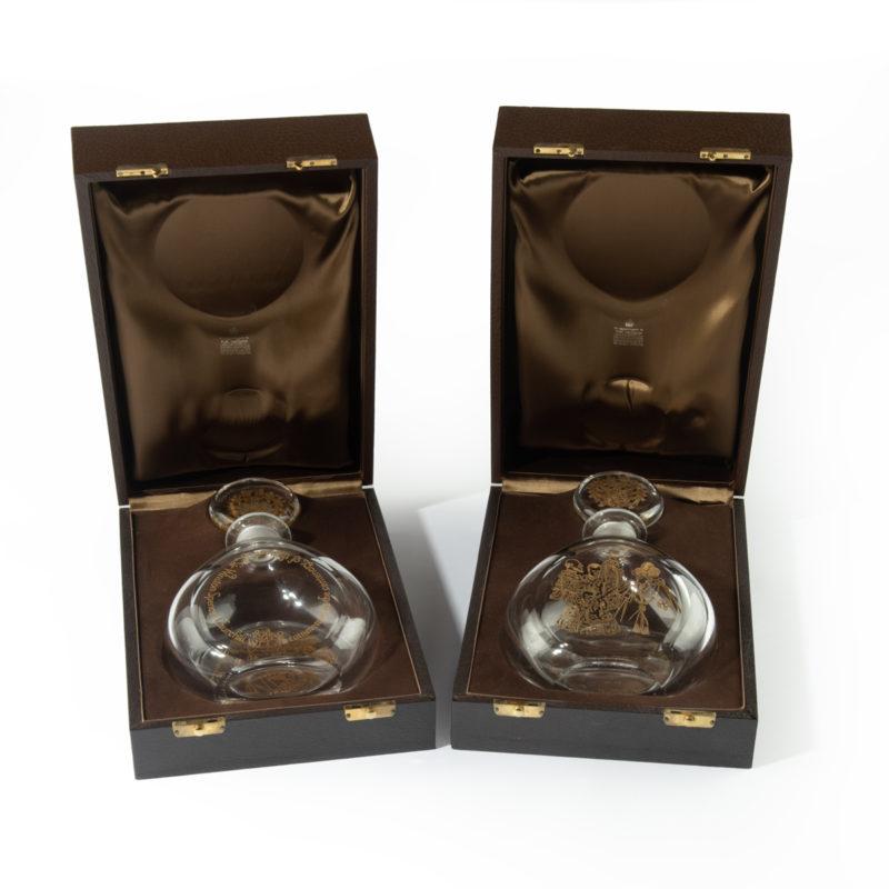 A pair of Sir Winston Churchill glass decanters, by Garrard & Co.,1974. These lead crystal decanters are numbers 27 and 28 in a limited edition of 100 Churchill decanters made by Orrefors for Garrard & Co.  Each is oviform and gilt-engraved with a