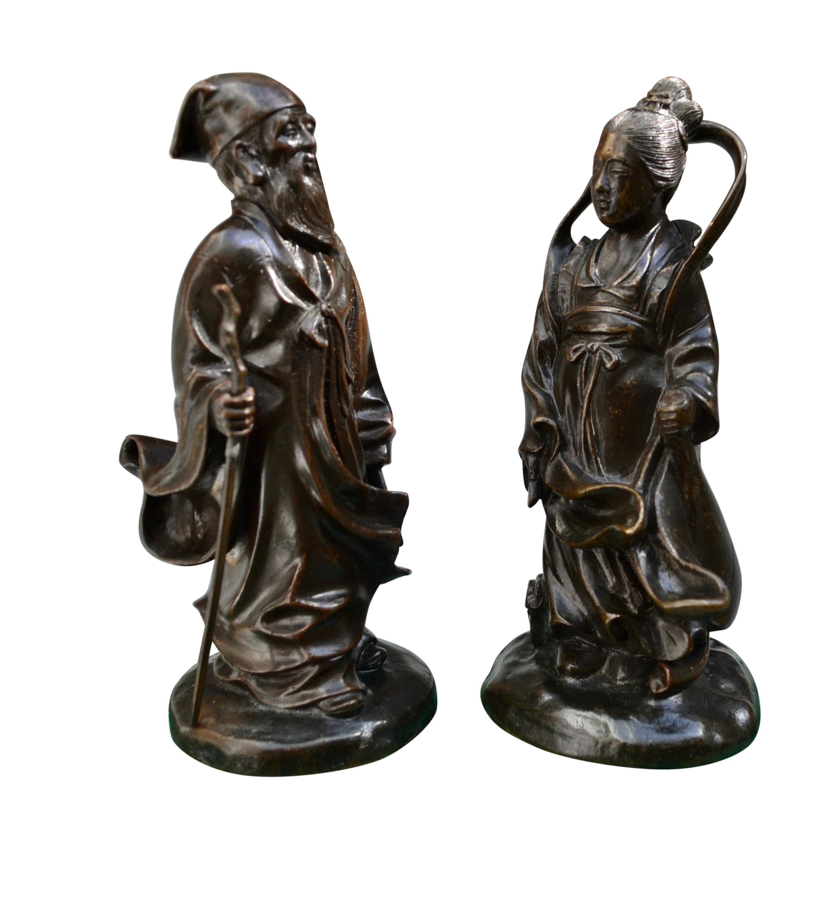 A pair of exceptional small patinated bronze castings of a male and female Chinese Deities or Gods possibly representing Shouxing God of Longevity Immortality and Good Fortune, and Guan Yin Goddess of Mercy.  Given the rubbing in the patination and