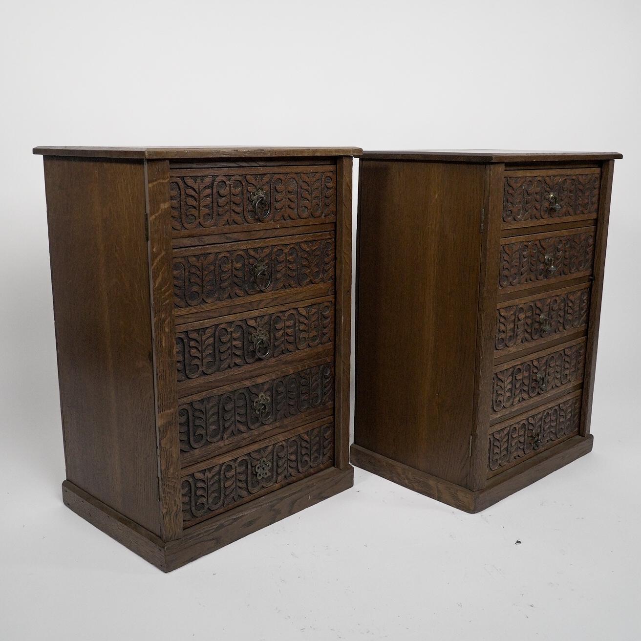 A pair of small Aesthetic Movement oak sets of drawers, with carved alternating fern leaf decoration to the drawer fronts and ring pull brass handles. The hinged sides with lockable side flaps. Price for the pair.